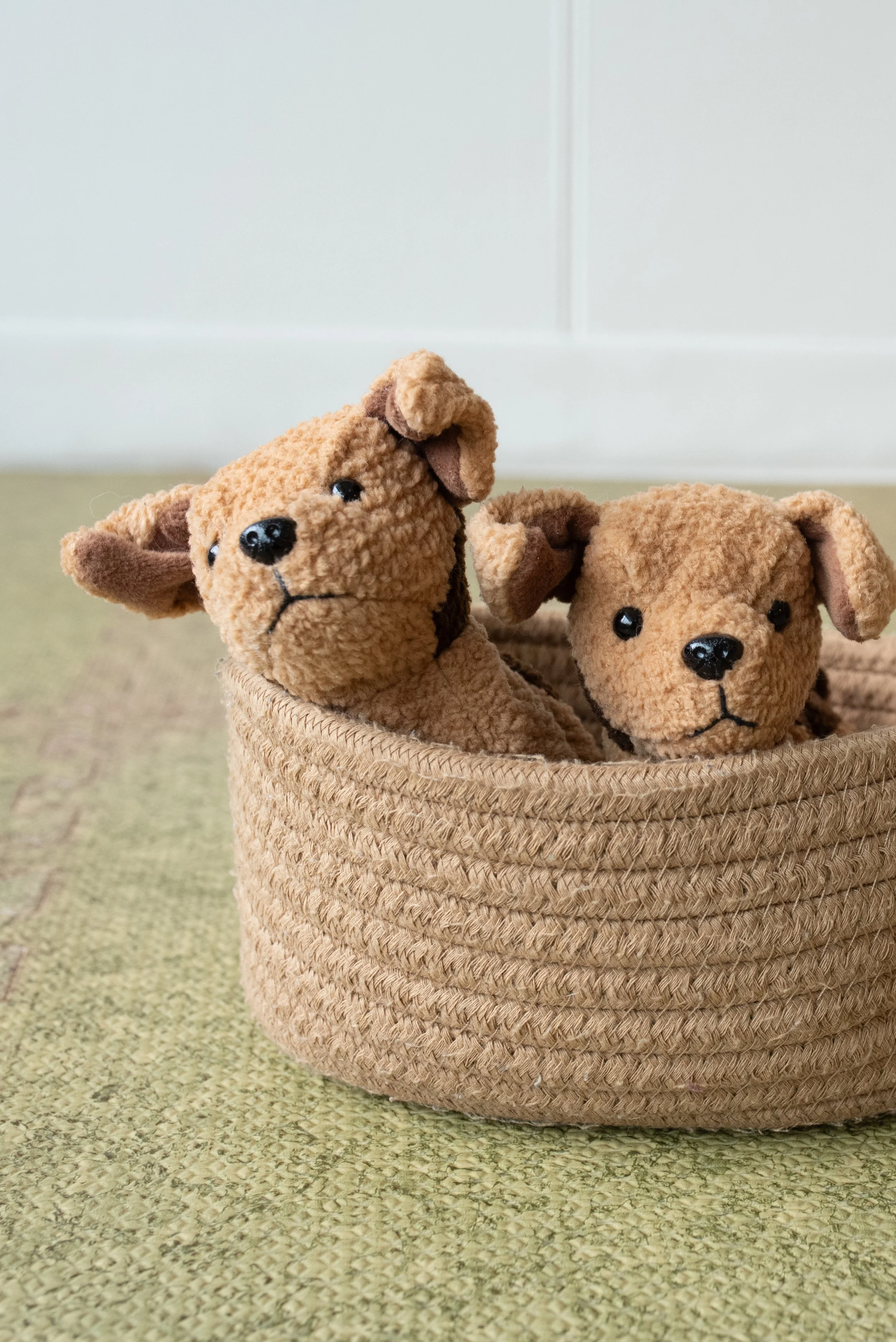 Two plush puppies in a brown basket