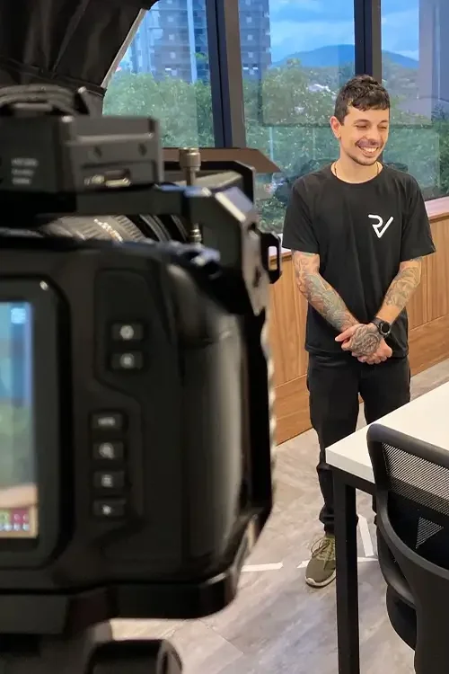 Cinegrafista captando cena com câmera profissional.