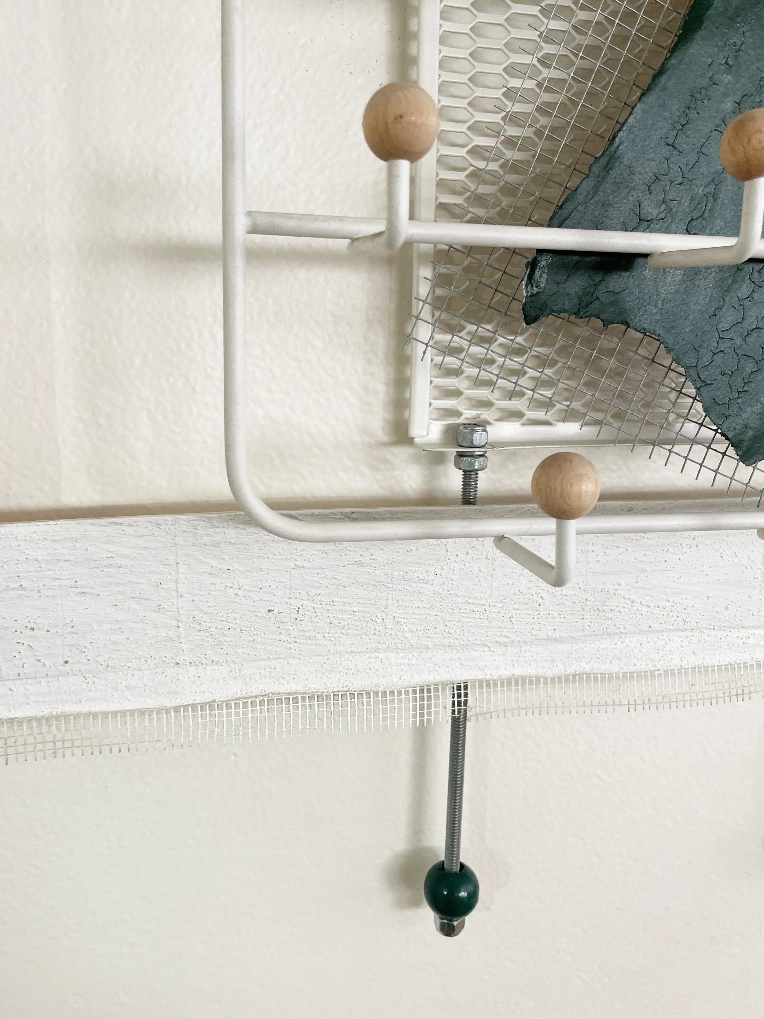 Untitled (french market), 2025-2026, 28h x 26.5w x 5d - salvaged barricade paper from the closed French Market restaurant, Ikea shelving, pre-mounted wood panel, prescription drug legal disclaimers, construction mesh, sheet rock tape, threaded rod, w