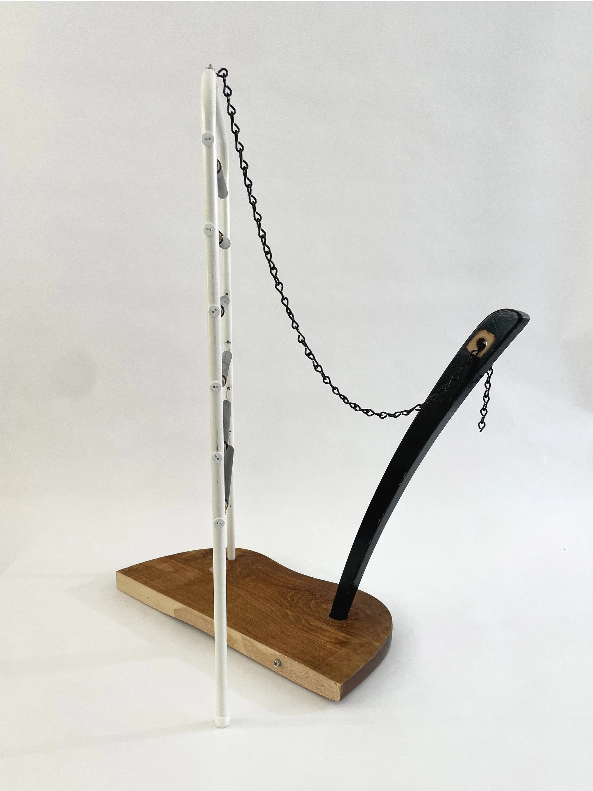 Untitled (harp), 2026, 26.5h x 21w x 13.5d - salvaged wood spindles, furniture leg, oak chair seat, Ikea aluminum legs, black zinc chain, buttons, wire, threaded rod, lock knots