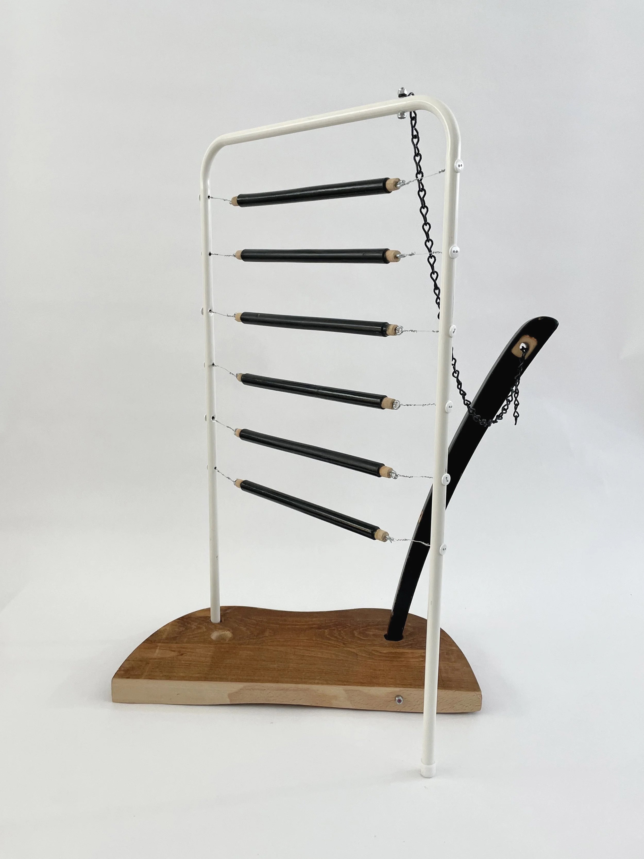 Untitled (harp), 2026, 26.5h x 21w x 13.5d - salvaged wood spindles, furniture leg, oak chair seat, Ikea aluminum legs, black zinc chain, buttons, wire, threaded rod, lock knots