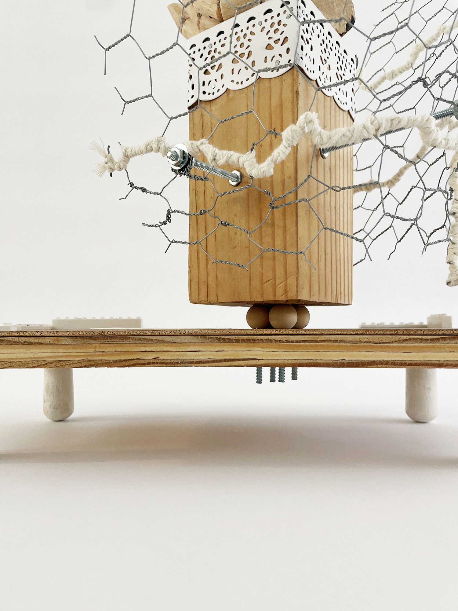 Untitled (Logan's Clock), 2025, 19h x 14w x 14d - salvaged plywood,4x4 lumber, walnut veneer, wood pegs {feet}, Ikea wooden model hand, chicken wire, butcher's string, Ikea metal trim, cotton fabric, threaded metal rod, wood beads, nuts, washers,