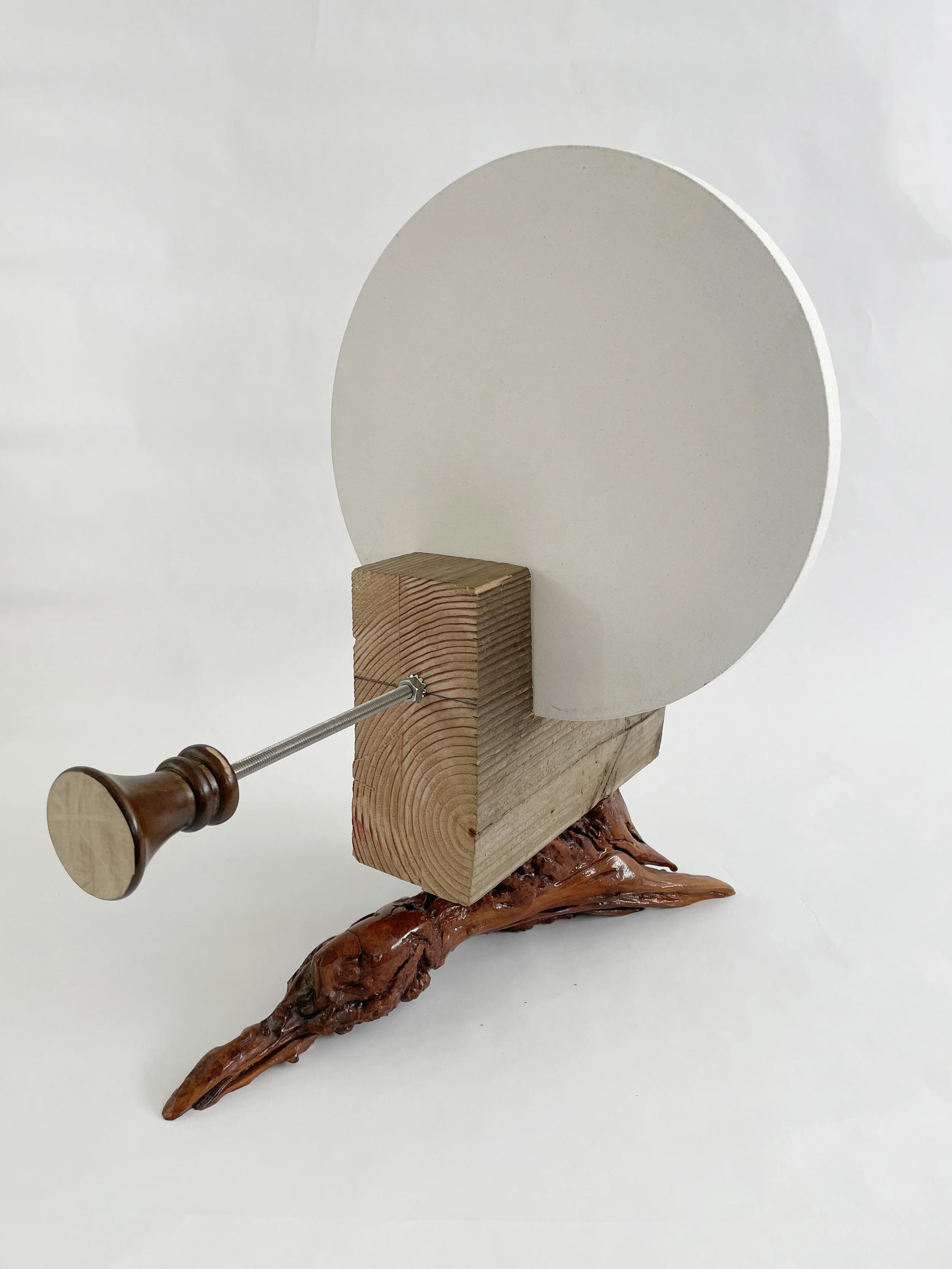 Untitled (two disks) 2025- 2026, 19.5h x 16w x 22d - thrift store resin coated driftwood, 3x7 construction timber, threaded rods, lock nuts, 2 pre-primed round stretched canvas, wood finials, dowels, wood beads.
