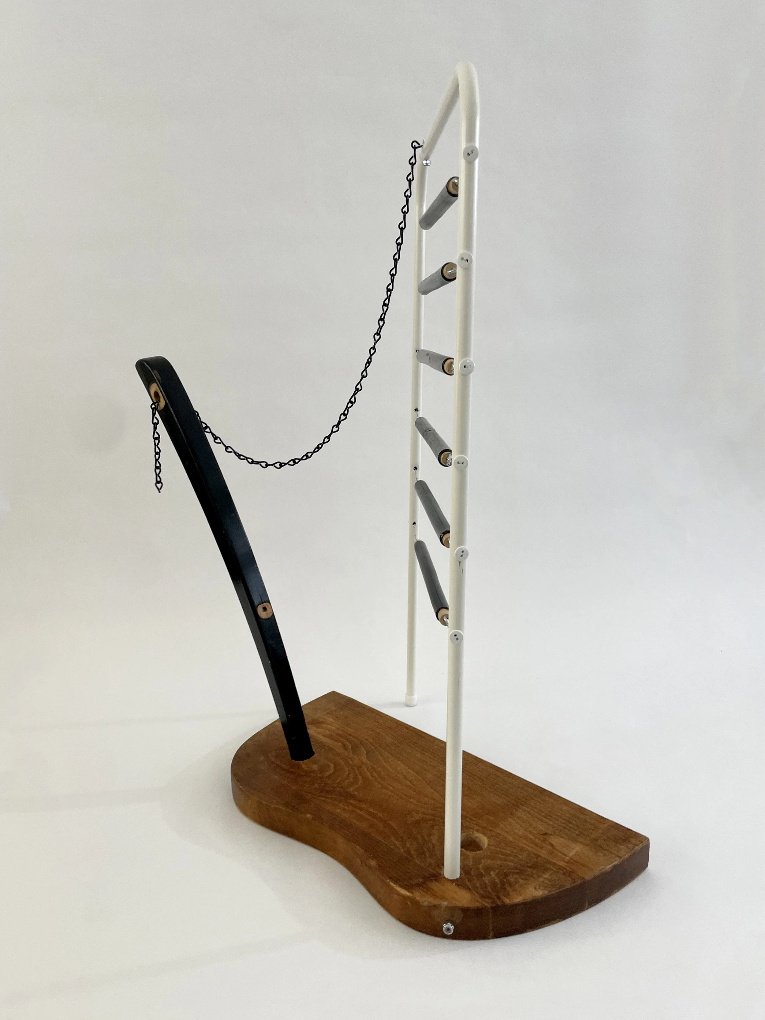 Untitled (harp), 2026, 26.5h x 21w x 13.5d - salvaged wood spindles, furniture leg, oak chair seat, Ikea aluminum legs, black zinc chain, buttons, wire, threaded rod, lock knots