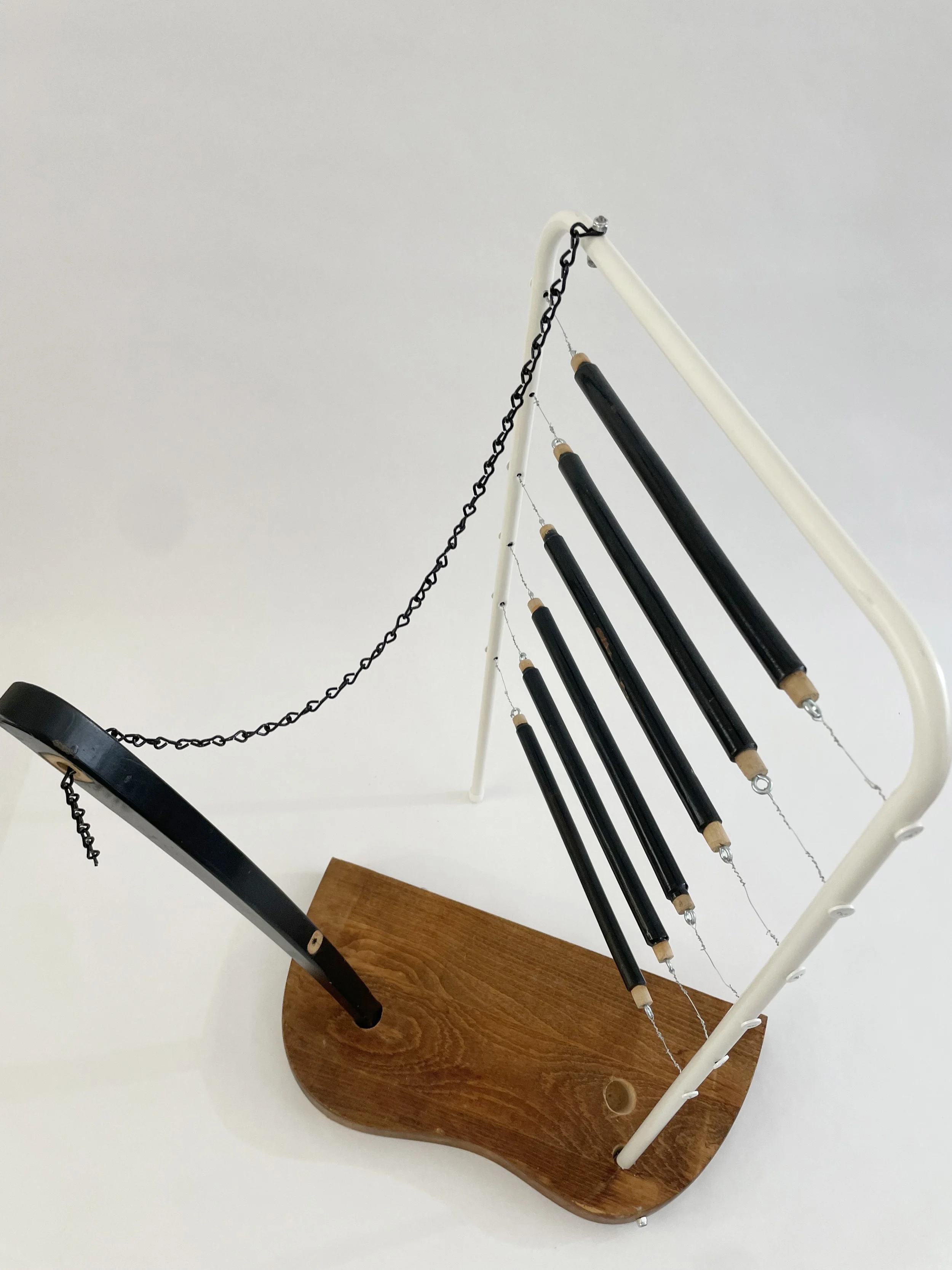 Untitled (harp), 2026, 26.5h x 21w x 13.5d - salvaged wood spindles, furniture leg, oak chair seat, Ikea aluminum legs, black zinc chain, buttons, wire, threaded rod, lock knots