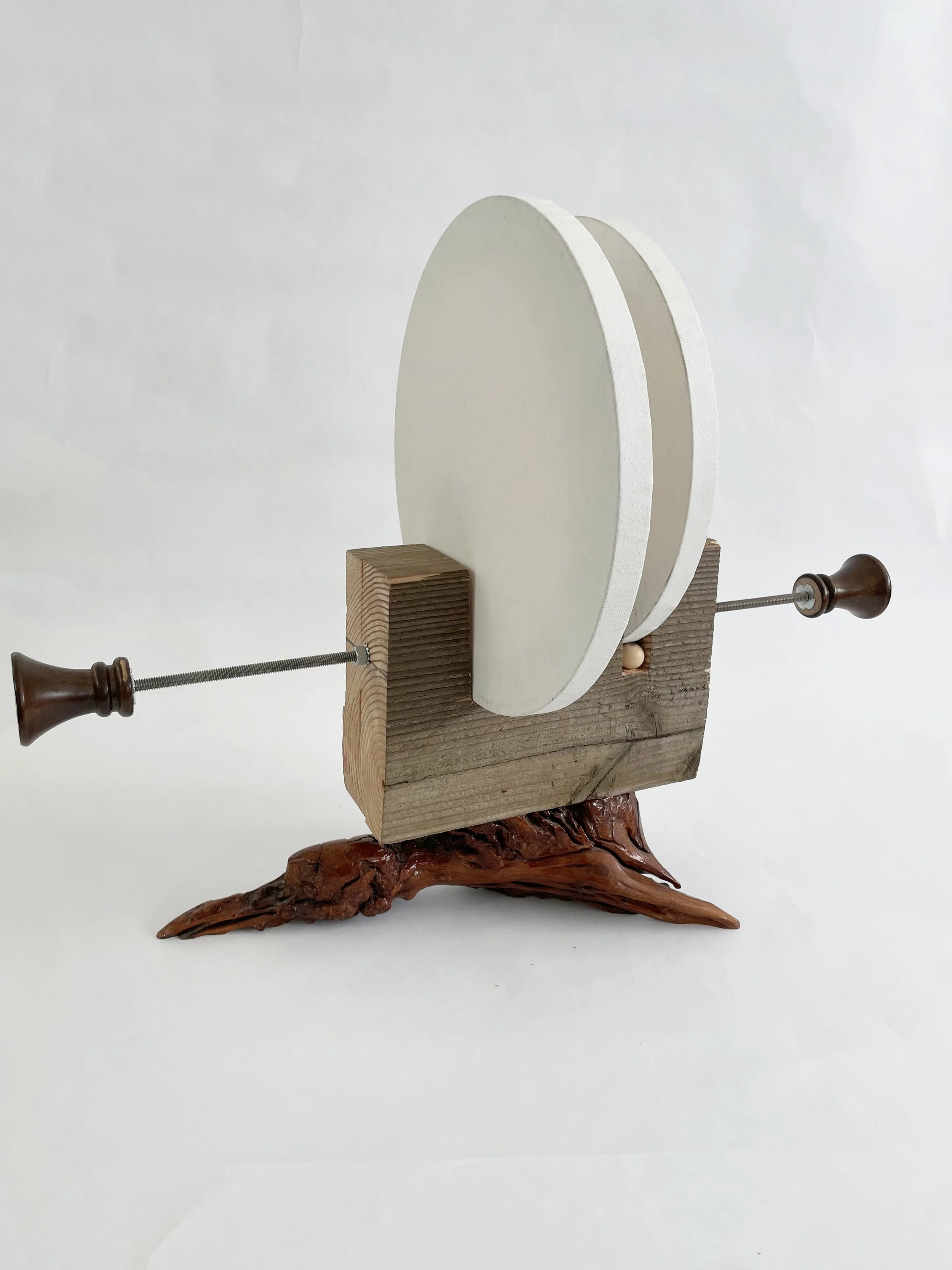 Untitled (two disks) 2025- 2026, 19.5h x 16w x 22d - thrift store resin coated driftwood, 3x7 construction timber, threaded rods, lock nuts, 2 pre-primed round stretched canvas, wood finials, dowels, wood beads.
