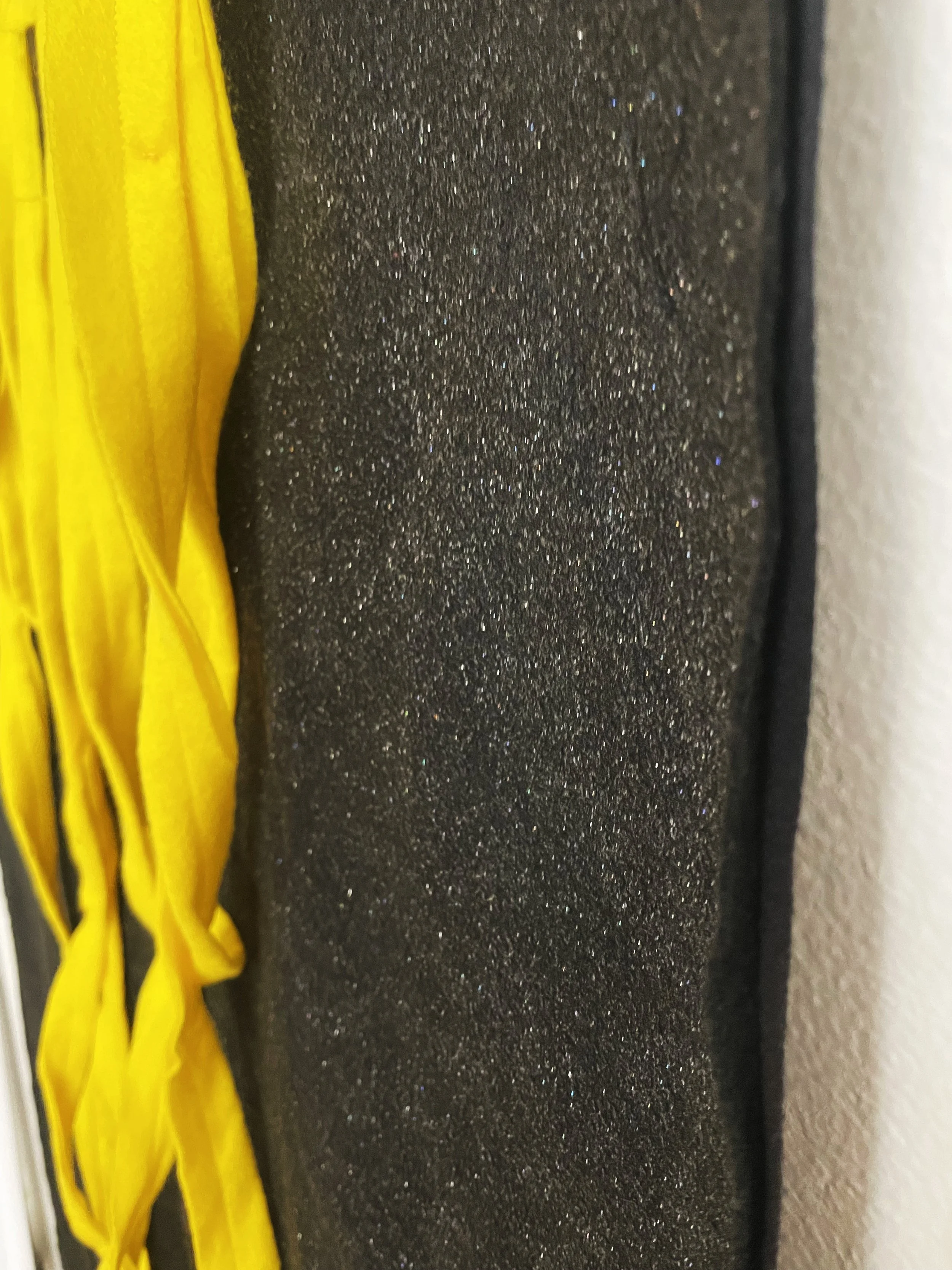 Untitled (the spaghetti tapestry), 2018-2026, 8’ x 3’, black sparkle felt, yellow felt, thread, cotton edging. (detail)