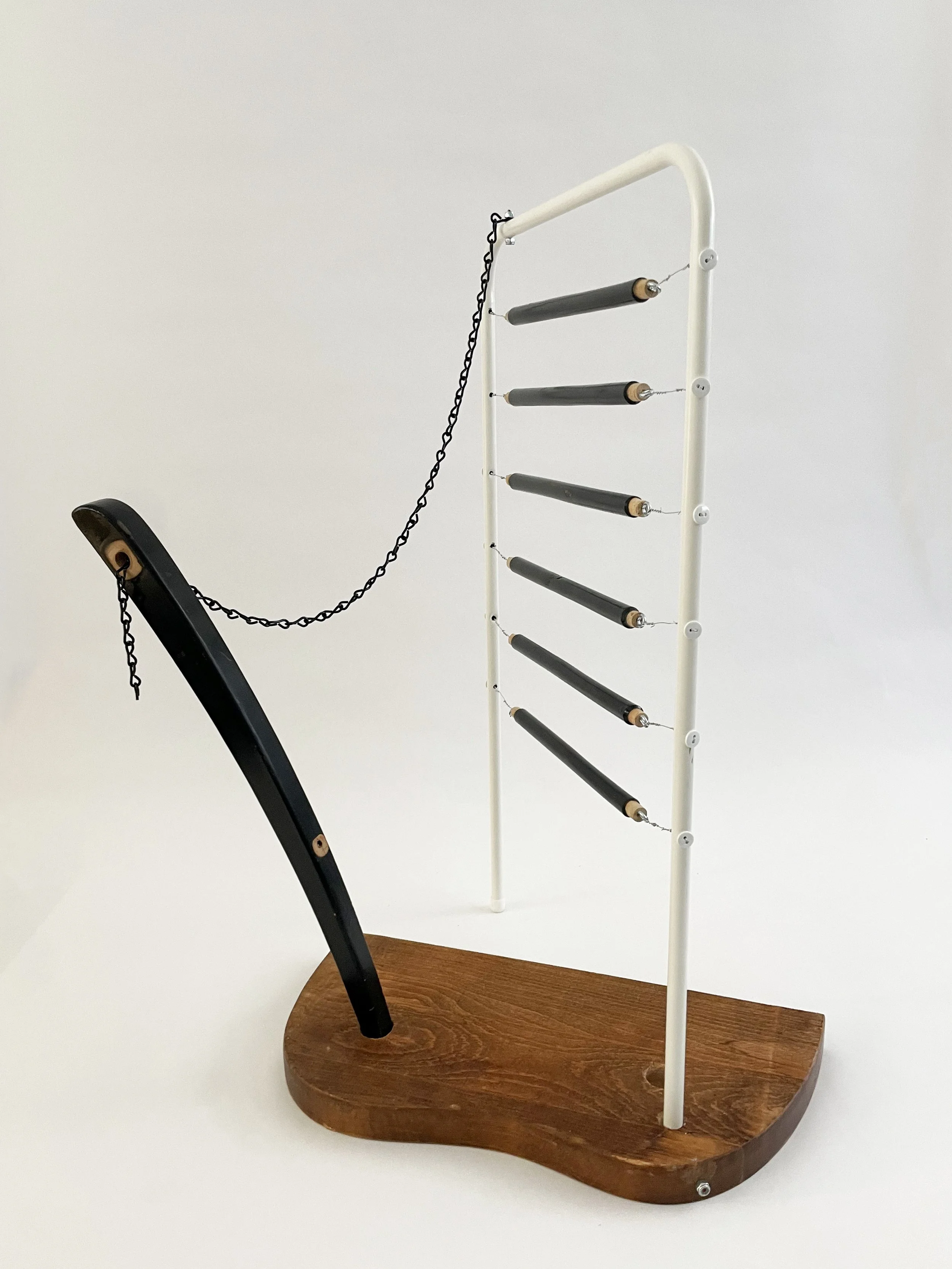 Untitled (harp), 2026, 26.5h x 21w x 13.5d - salvaged wood spindles, furniture leg, oak chair seat, Ikea aluminum legs, black zinc chain, buttons, wire, threaded rod, lock knots