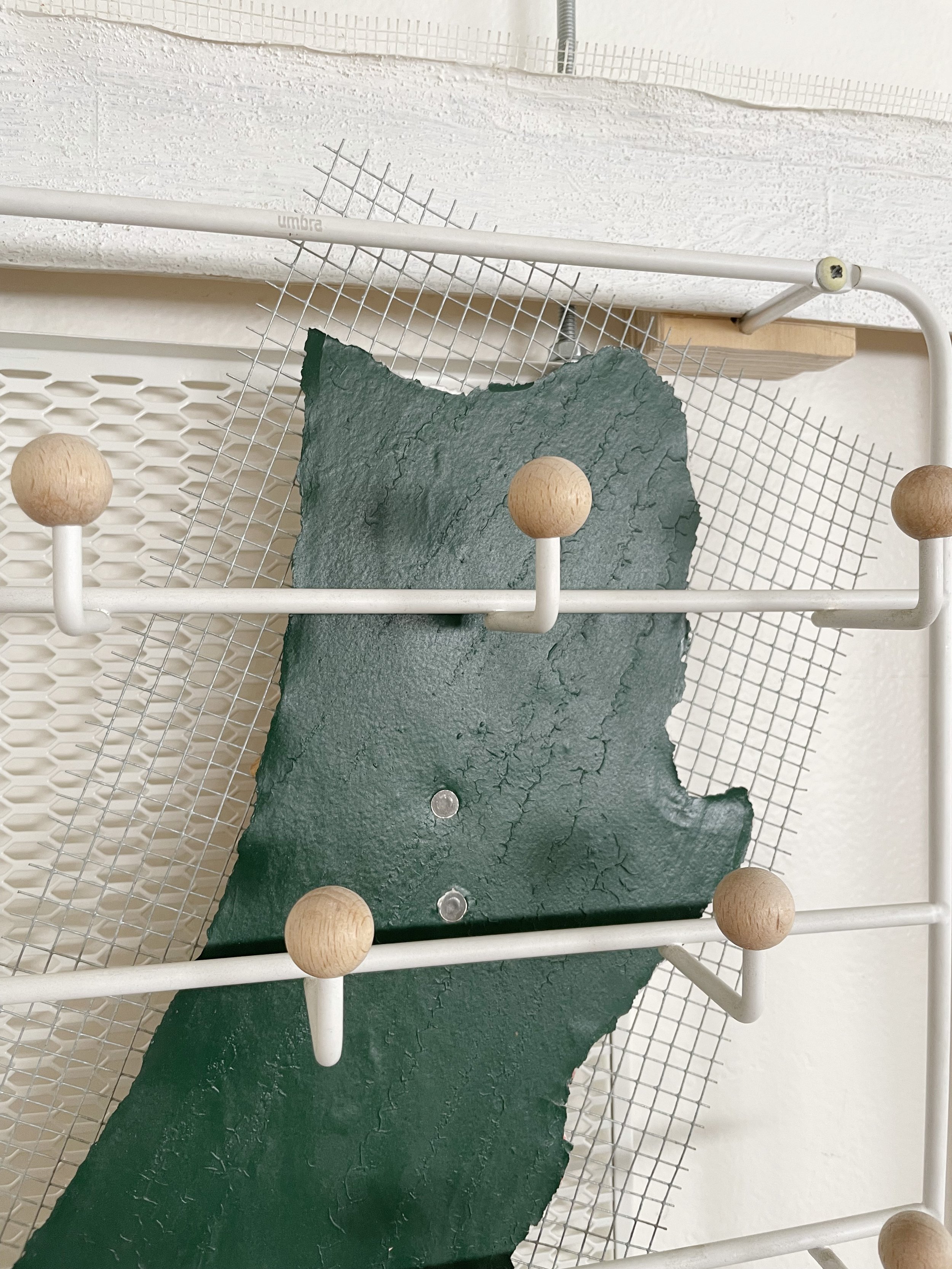 Untitled (french market), 2025-2026, 28h x 26.5w x 5d - salvaged barricade paper from the closed French Market restaurant, Ikea shelving, pre-mounted wood panel, prescription drug legal disclaimers, construction mesh, sheet rock tape, threaded rod, w