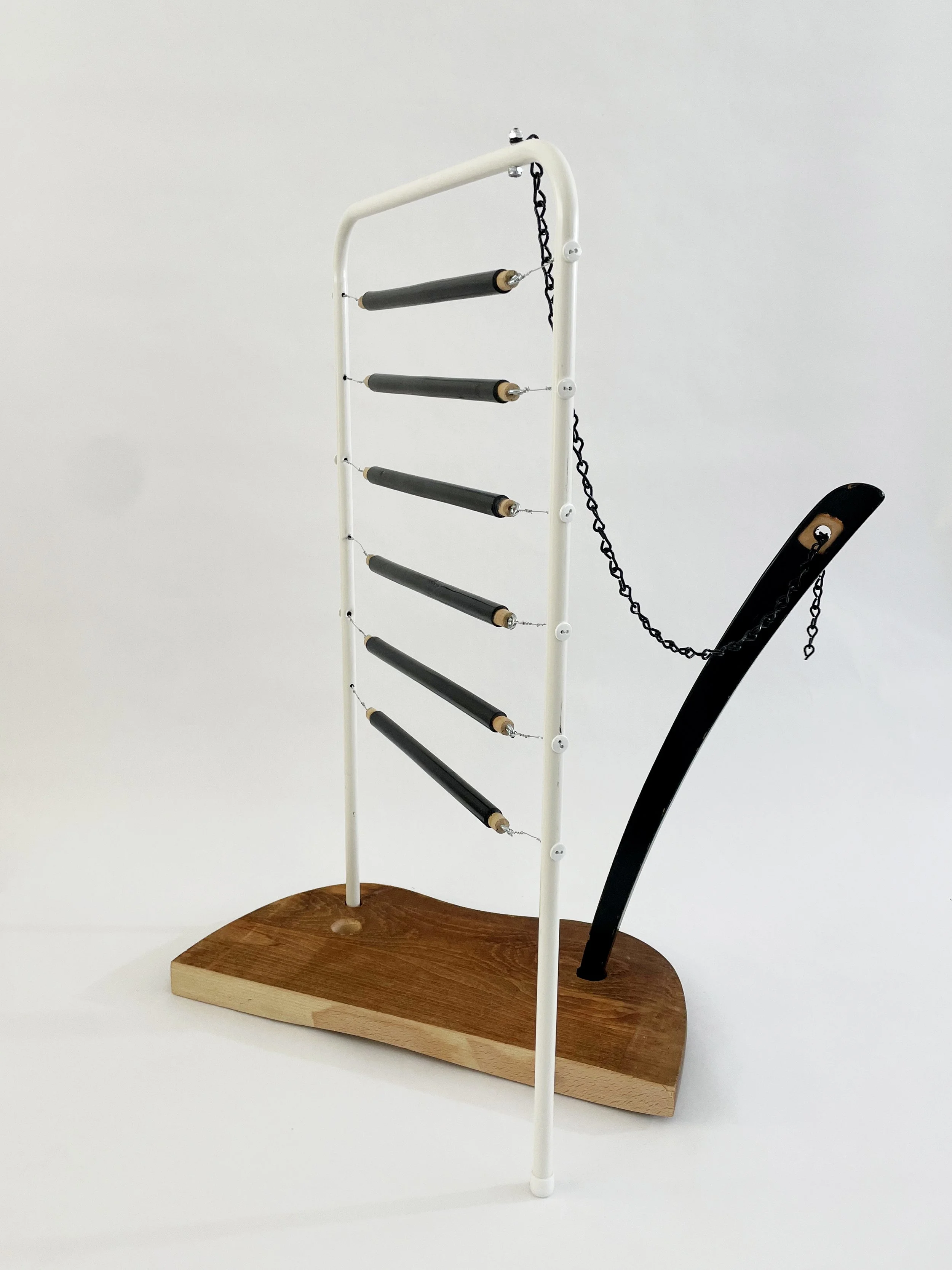 Untitled (harp), 2026, 26.5h x 21w x 13.5d - salvaged wood spindles, furniture leg, oak chair seat, Ikea aluminum legs, black zinc chain, buttons, wire, threaded rod, lock knots
