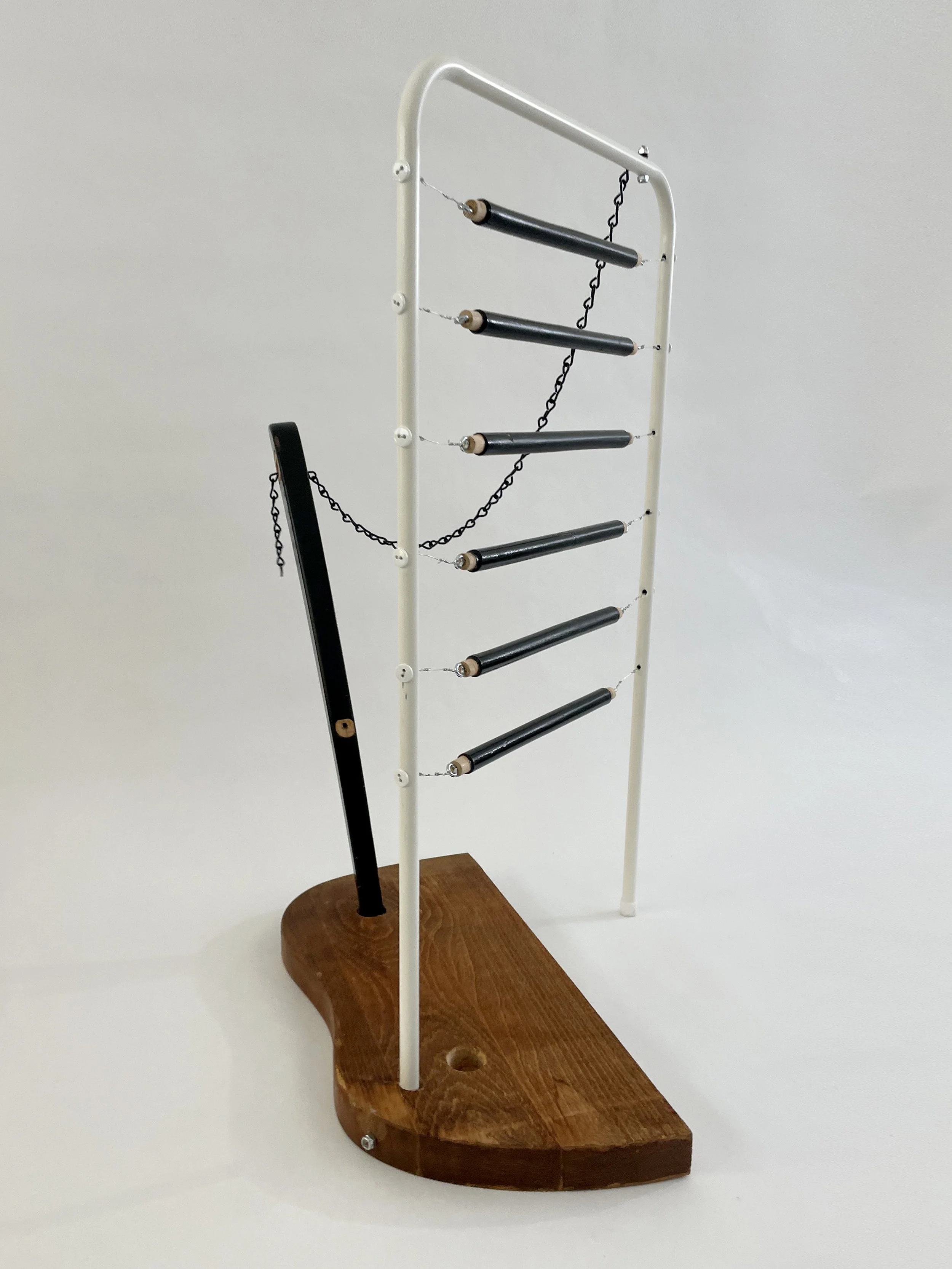 Untitled (harp), 2026, 26.5h x 21w x 13.5d - salvaged wood spindles, furniture leg, oak chair seat, Ikea aluminum legs, black zinc chain, buttons, wire, threaded rod, lock knots