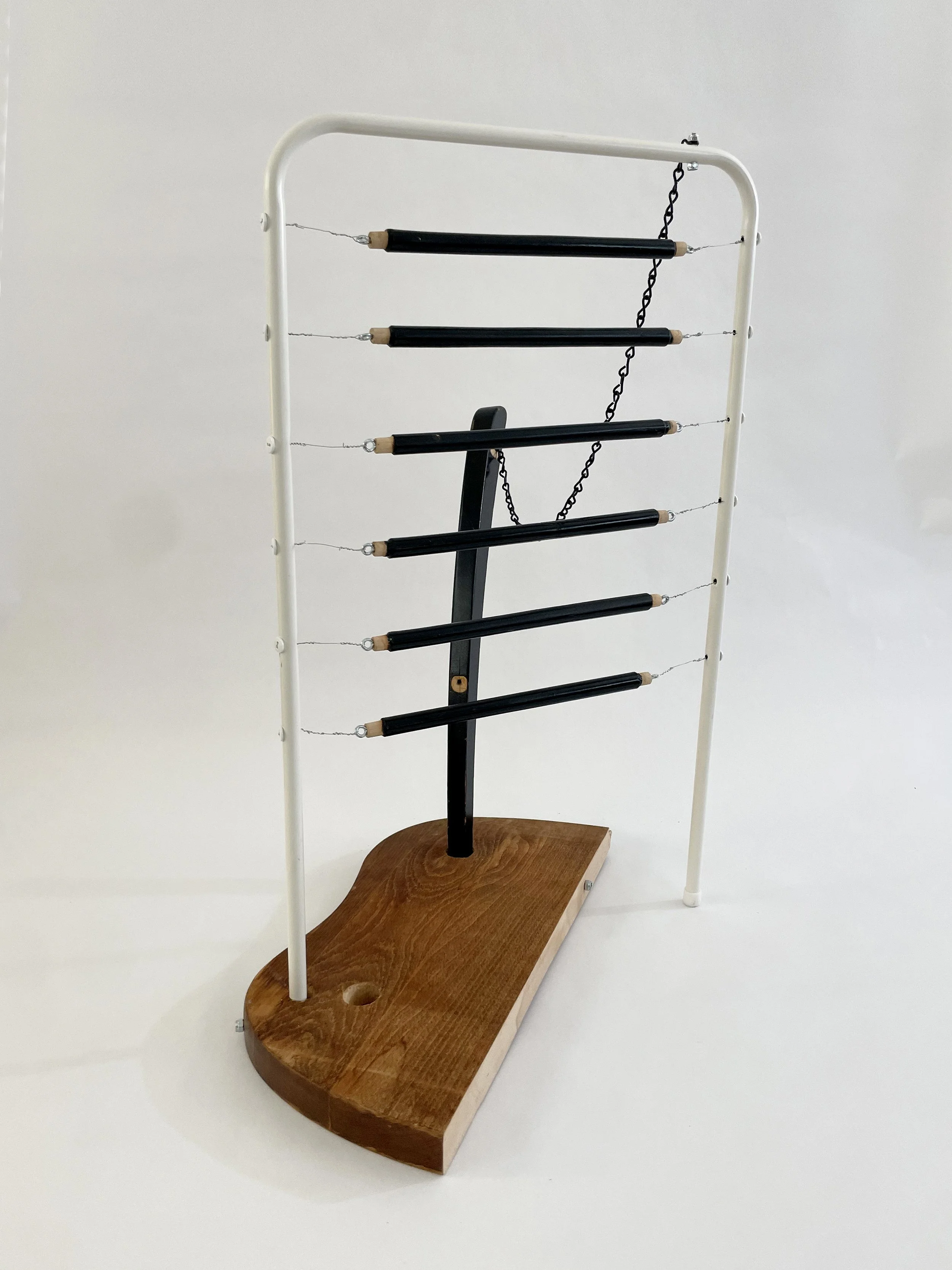 Untitled (harp), 2026, 26.5h x 21w x 13.5d - salvaged wood spindles, furniture leg, oak chair seat, Ikea aluminum legs, black zinc chain, buttons, wire, threaded rod, lock knots