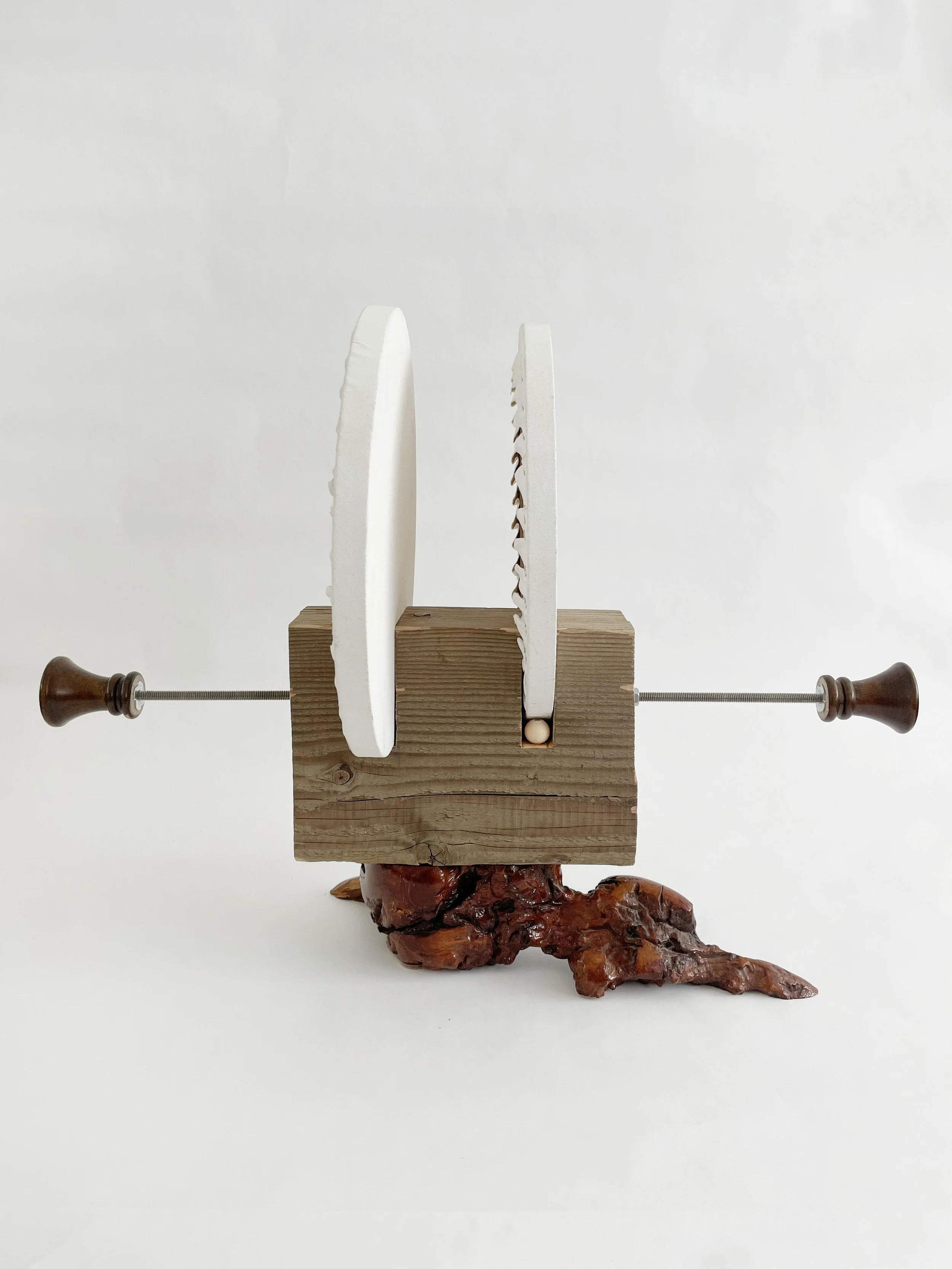Untitled (two disks) 2025- 2026, 19.5h x 16w x 22d - thrift store resin coated driftwood, 3x7 construction timber, threaded rods, lock nuts, 2 pre-primed round stretched canvas, wood finials, dowels, wood beads.