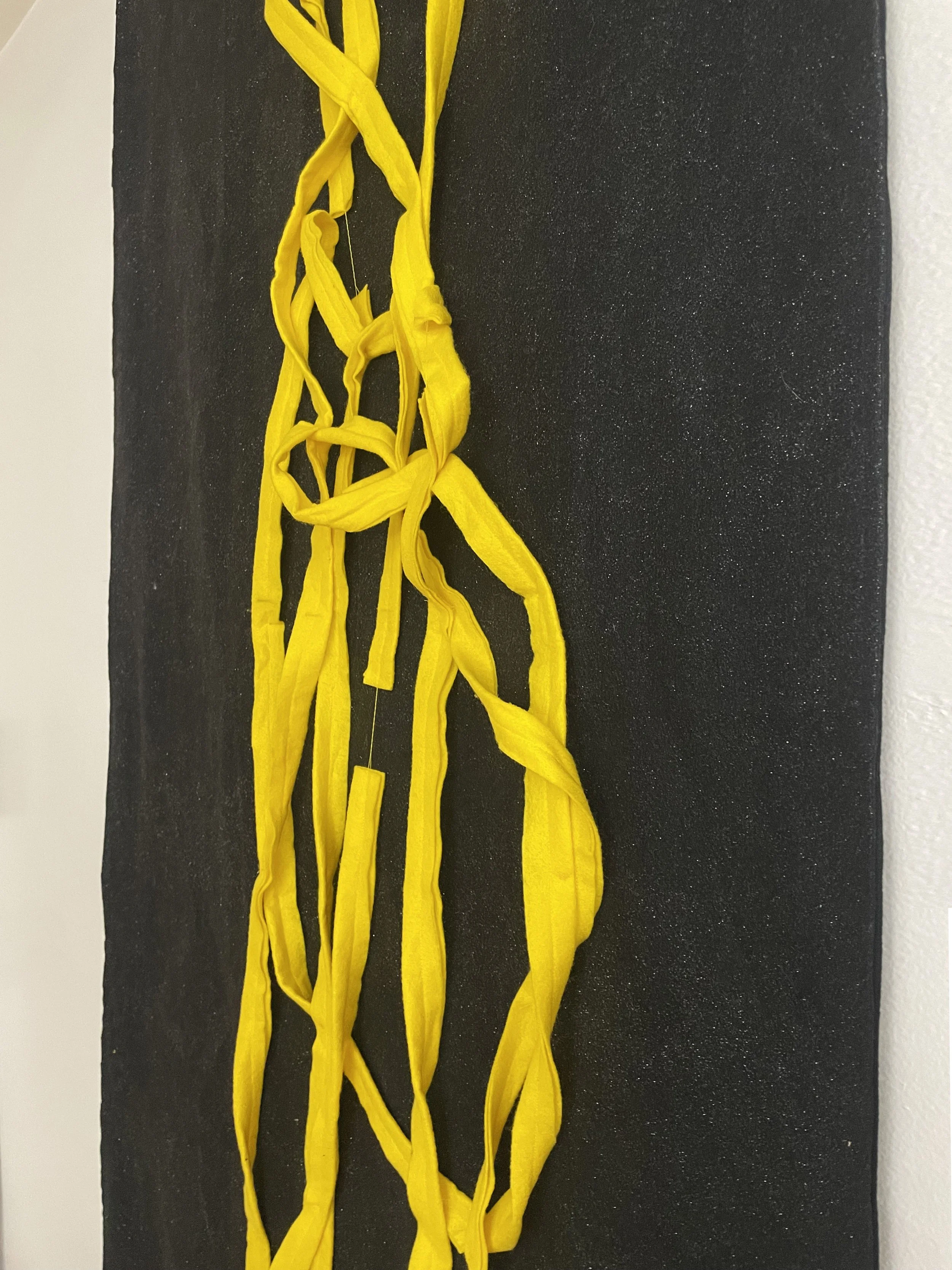 Untitled (the spaghetti tapestry), 2018-2026, 8’ x 3’, black sparkle felt, yellow felt, thread, cotton edging. (detail)