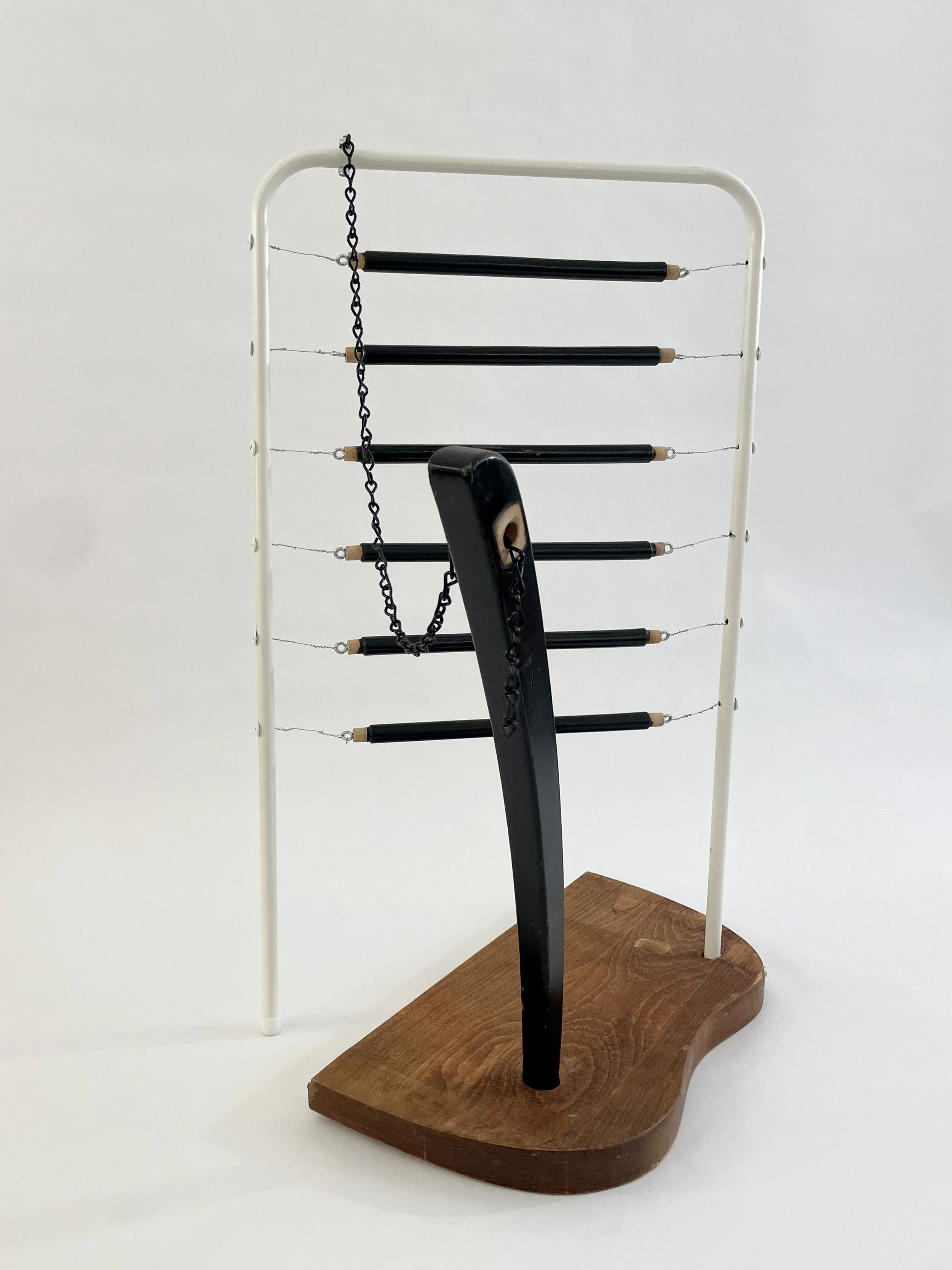 Untitled (harp), 2026, 26.5h x 21w x 13.5d - salvaged wood spindles, furniture leg, oak chair seat, Ikea aluminum legs, black zinc chain, buttons, wire, threaded rod, lock knots