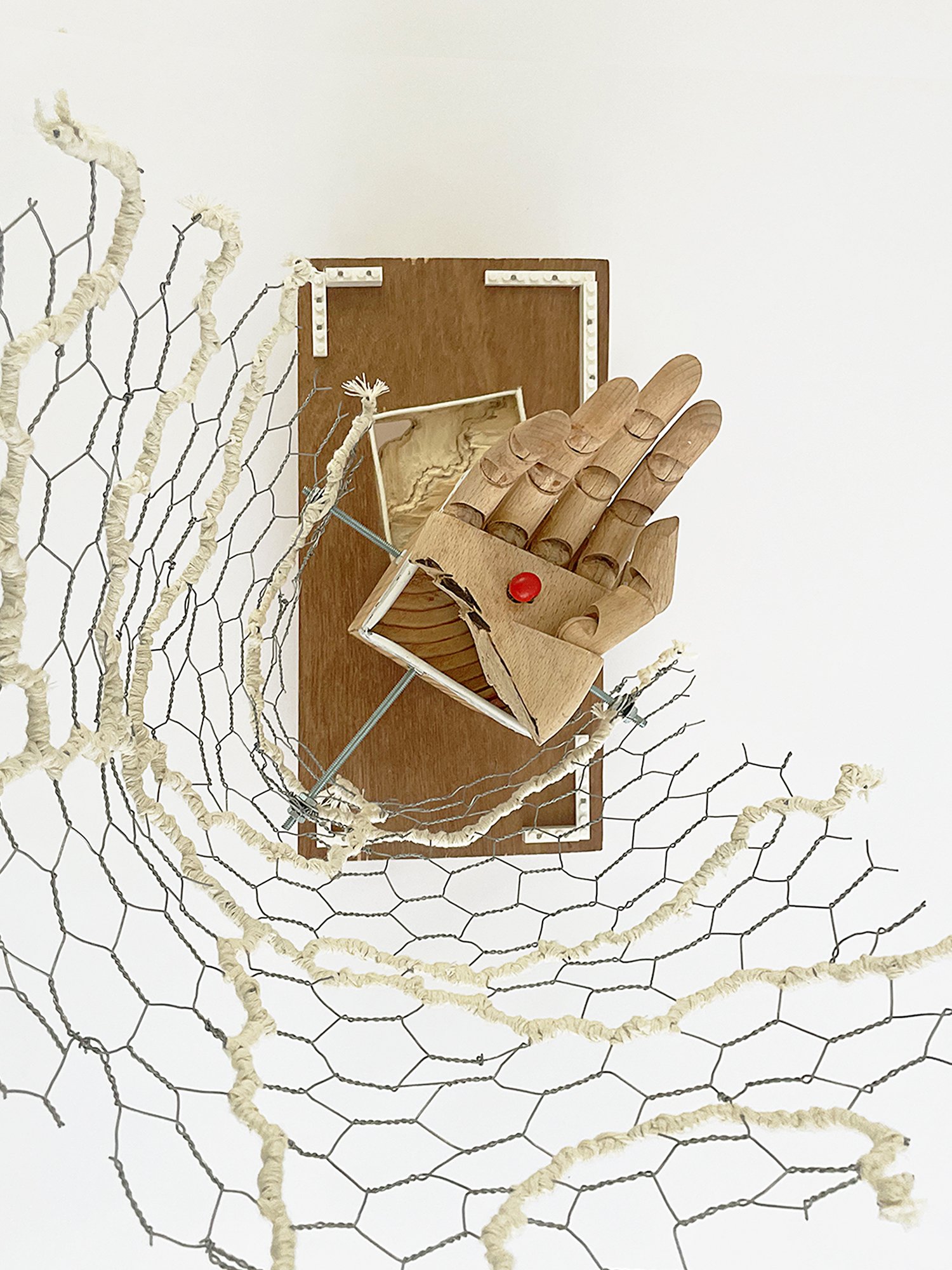Untitled (Logan's Clock), 2025, 19h x 14w x 14d - salvaged plywood,4x4 lumber, walnut veneer, wood pegs {feet}, Ikea wooden model hand, chicken wire, butcher's string, Ikea metal trim, cotton fabric, threaded metal rod, wood beads, nuts, washers,