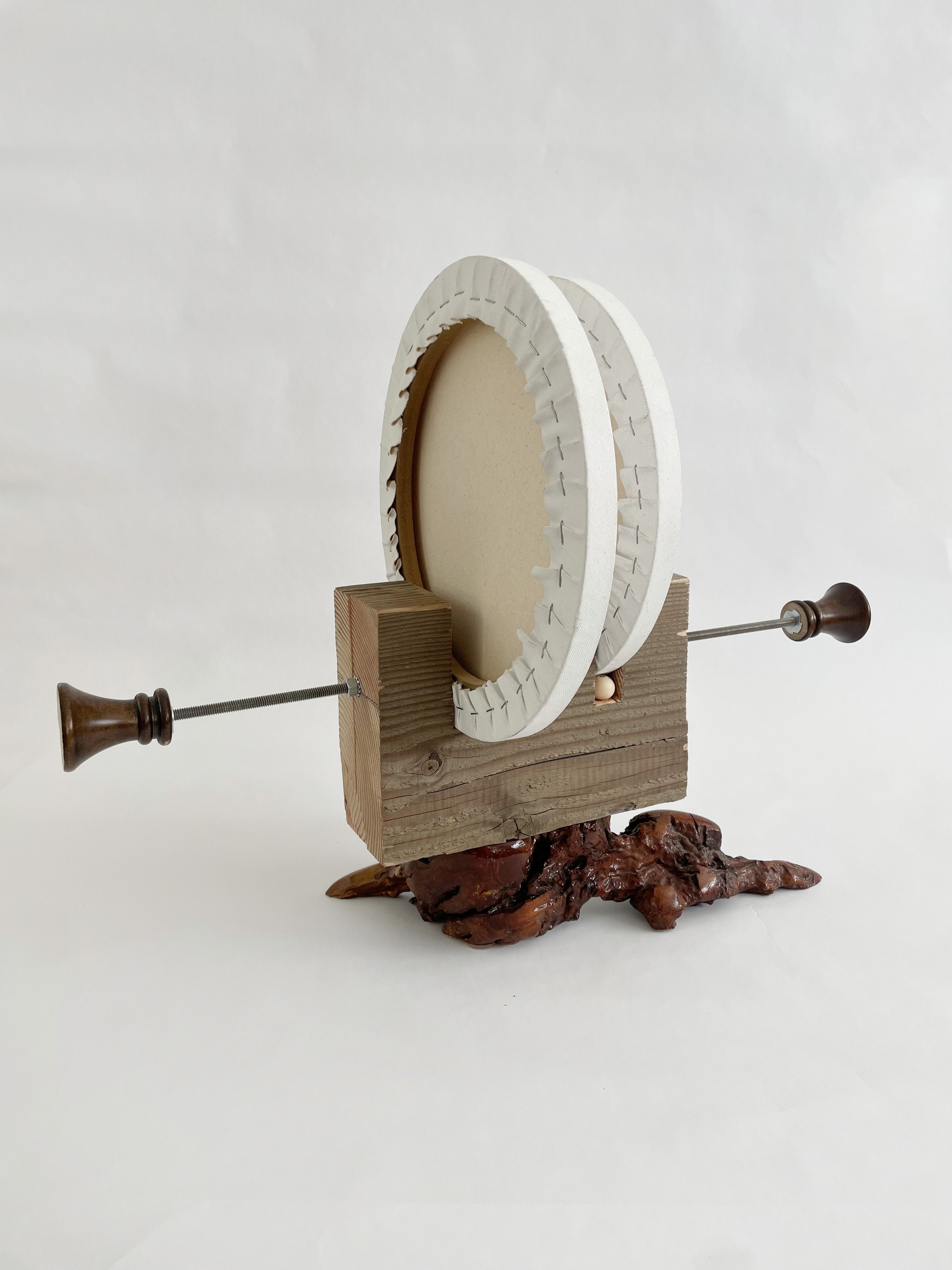 Untitled (two disks) 2025- 2026, 19.5h x 16w x 22d - thrift store resin coated driftwood, 3x7 construction timber, threaded rods, lock nuts, 2 pre-primed round stretched canvas, wood finials, dowels, wood beads.