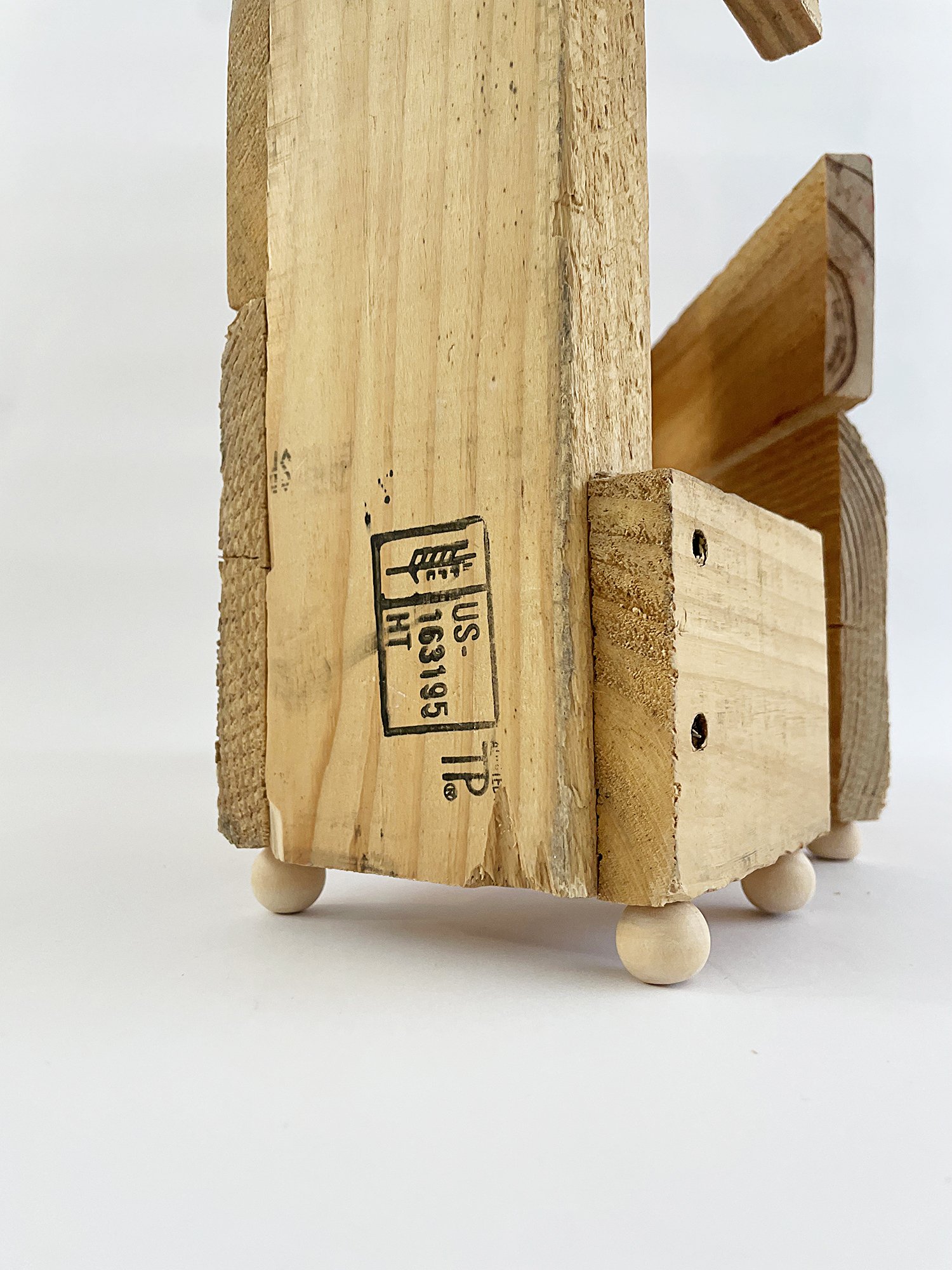 Untitled (Three Graces), 2025, 37h x 32w x 11d - salvaged wood pallet, wood balls {feet}, threaded rod, epoxy, wood glue, dowels