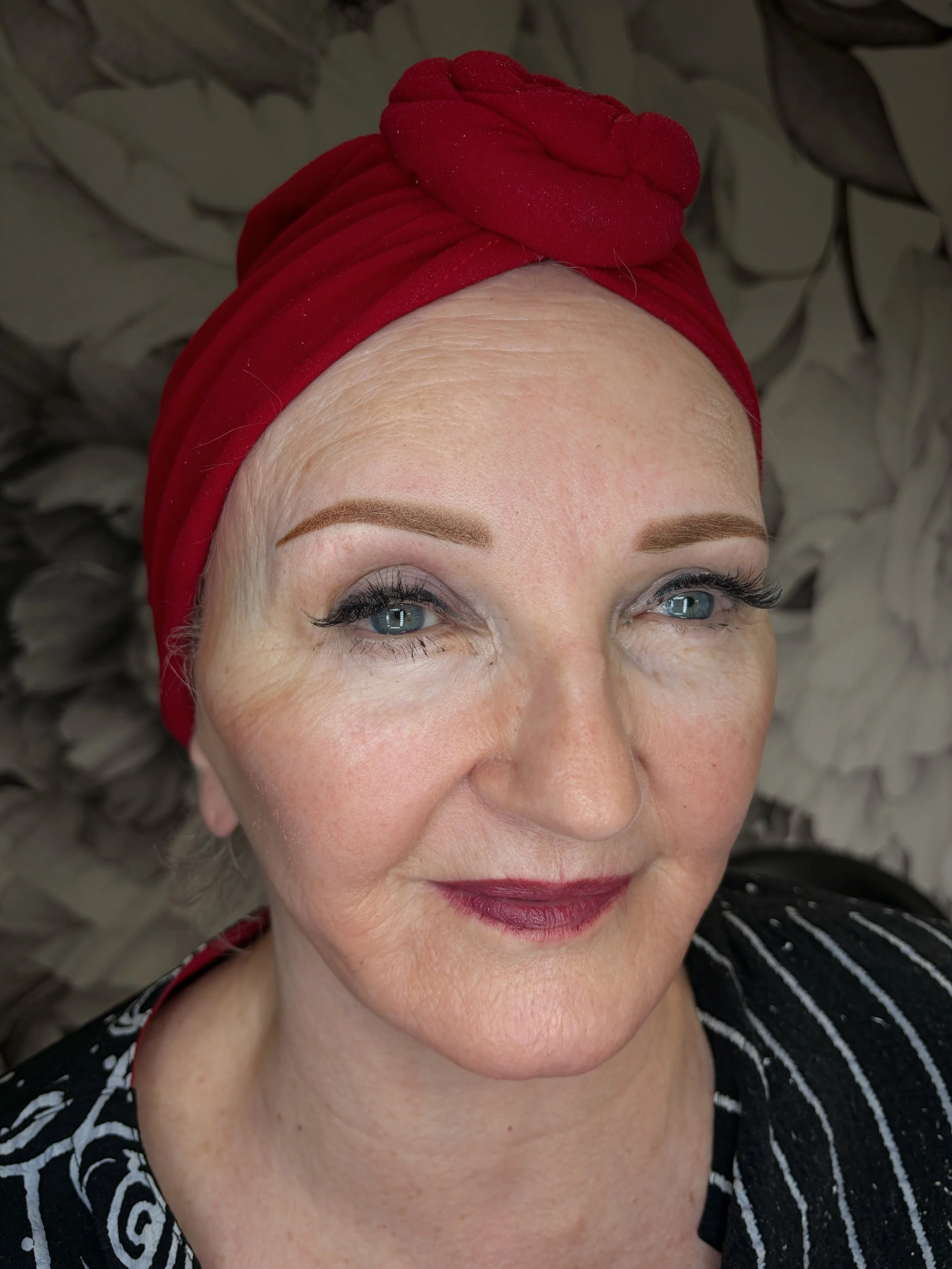 The same client in a red headwrap immediately after Powder Brows, with more defined brow shape and tails.