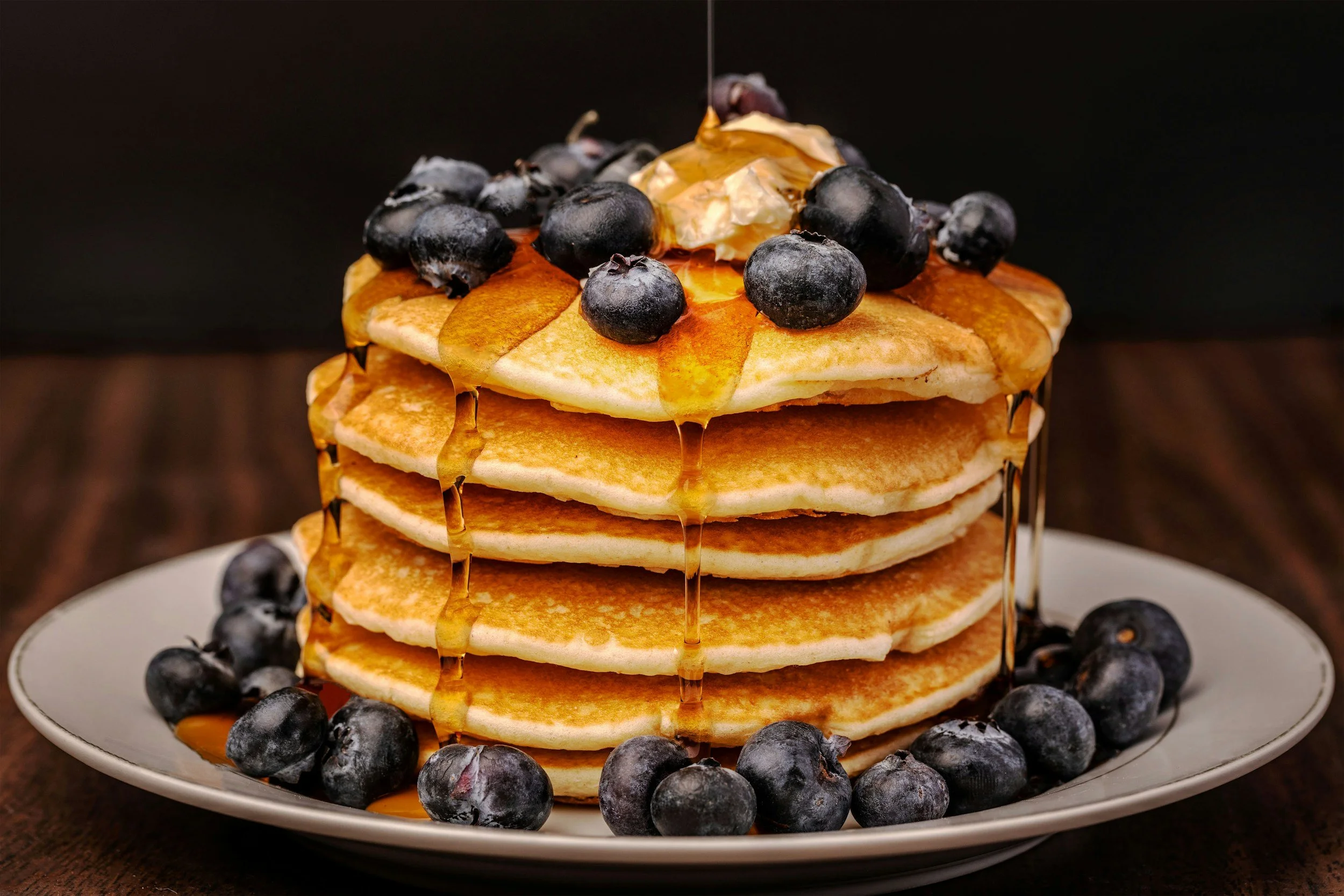 High-protein pancakes stacked with syrup and blueberries – quick family breakfast recipe for busy parents