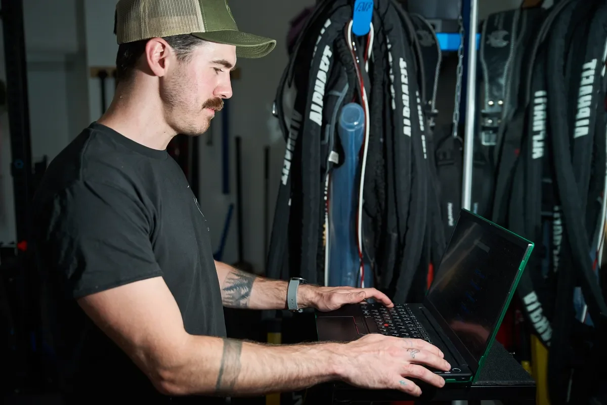 Coach Josh working at a laptop from a home gym