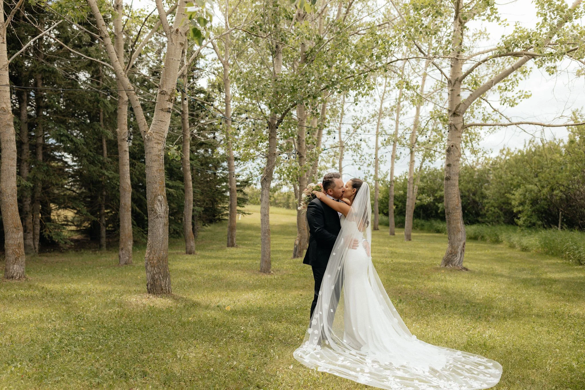Bride and groom outside under the trees, at a Calgary wedding venue.