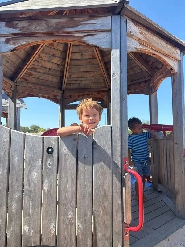 smiling children on play structure at daycare