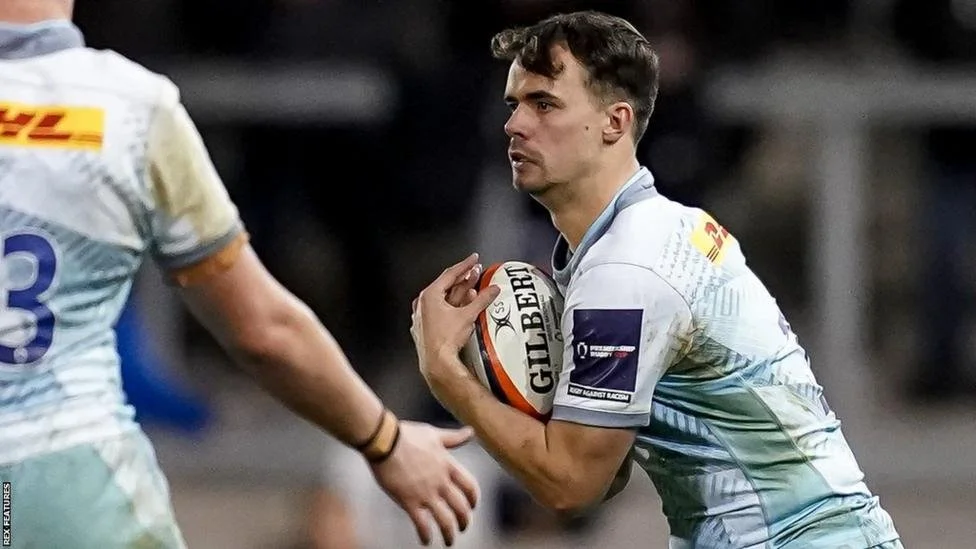 Rugby player in action holding a ball during a match.