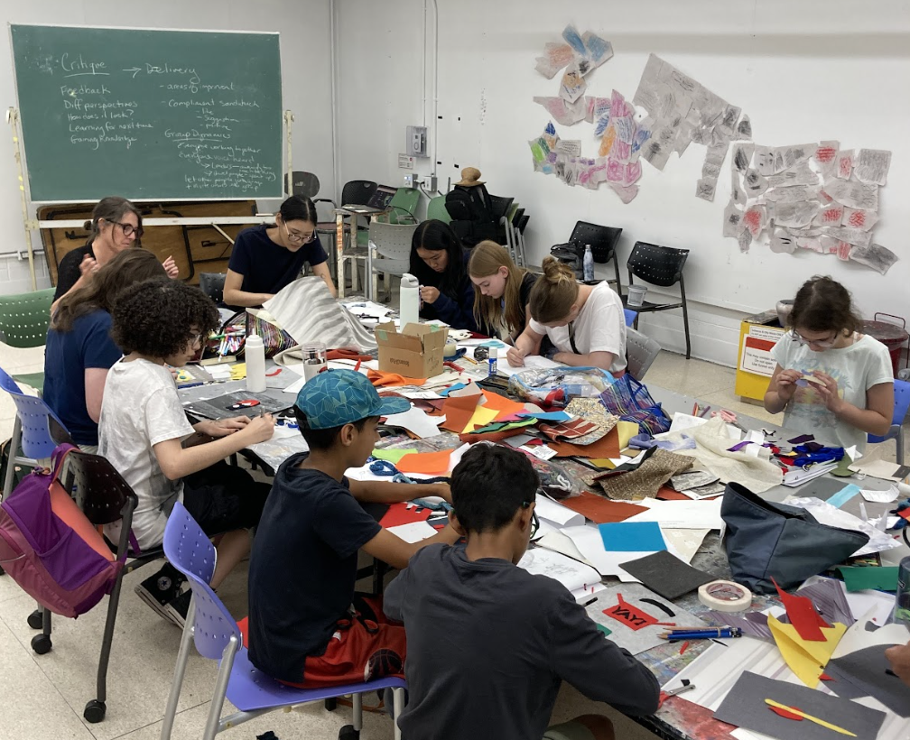 Group of students in a studio discovering and working on craft and art project with an instructor
