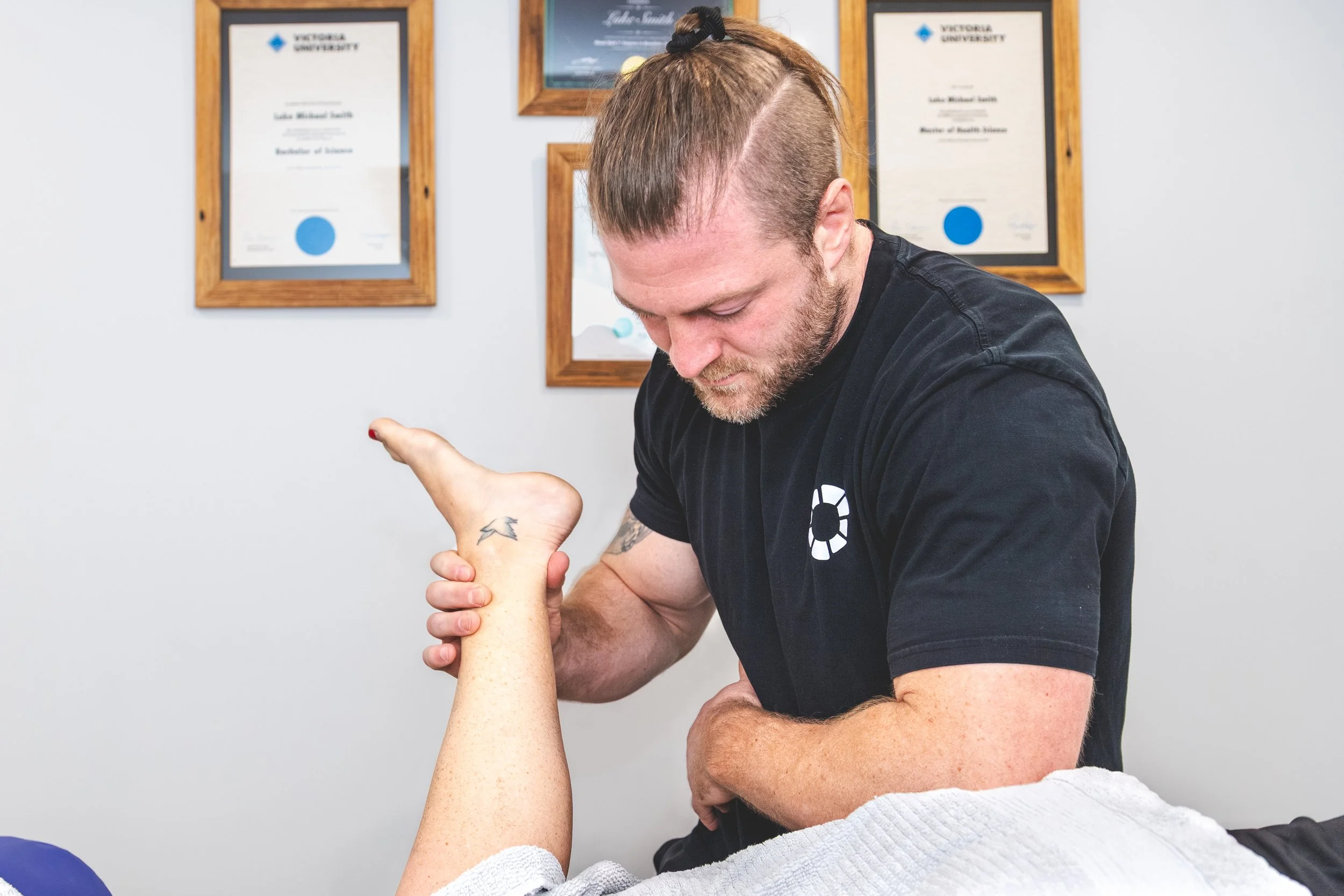 Close-up of Nick Mann applying targeted pressure to a client's forearm at Mixed Osteo