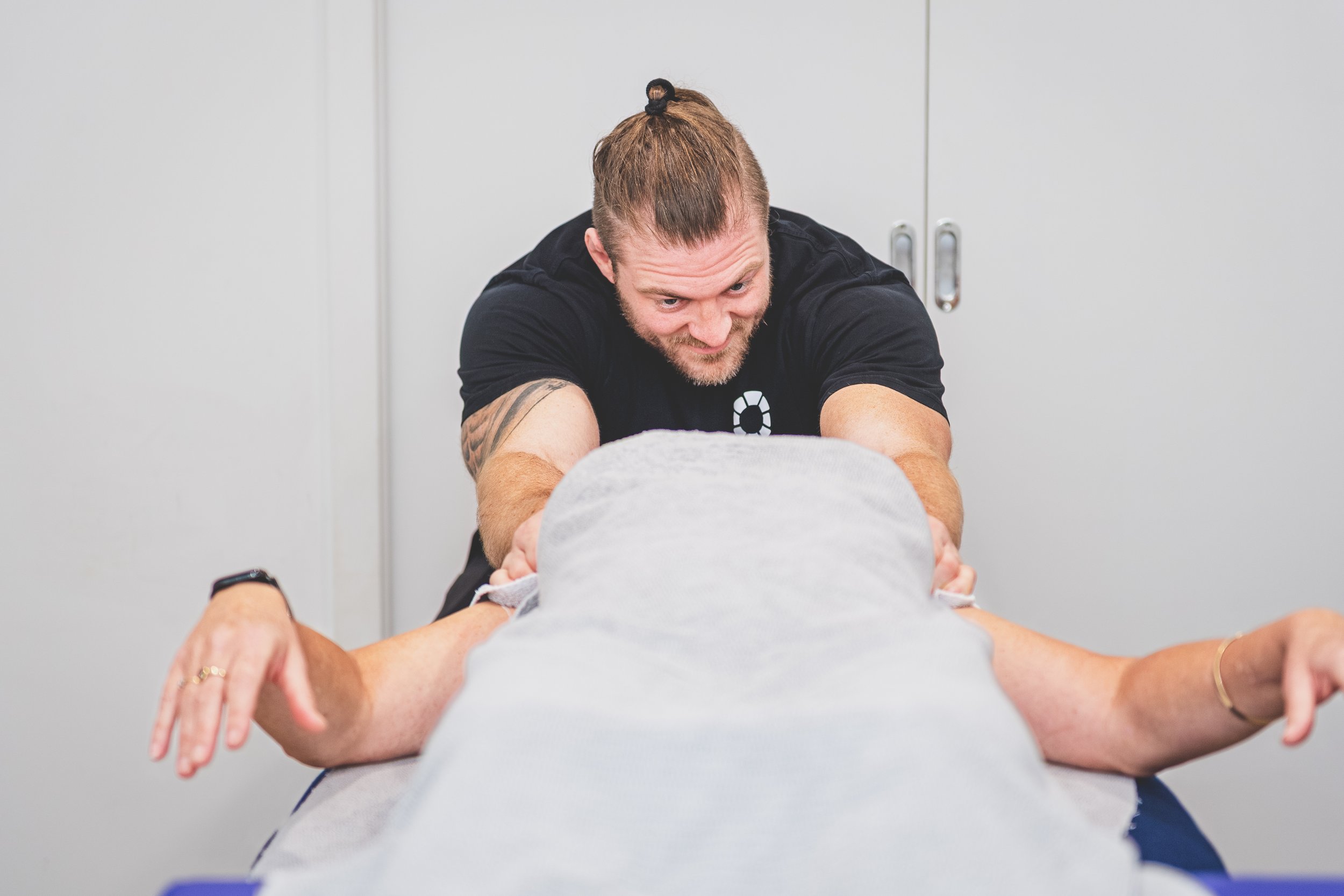 Nick Mann treating a client's neck during a remedial massage session at Mixed Osteo Kensington