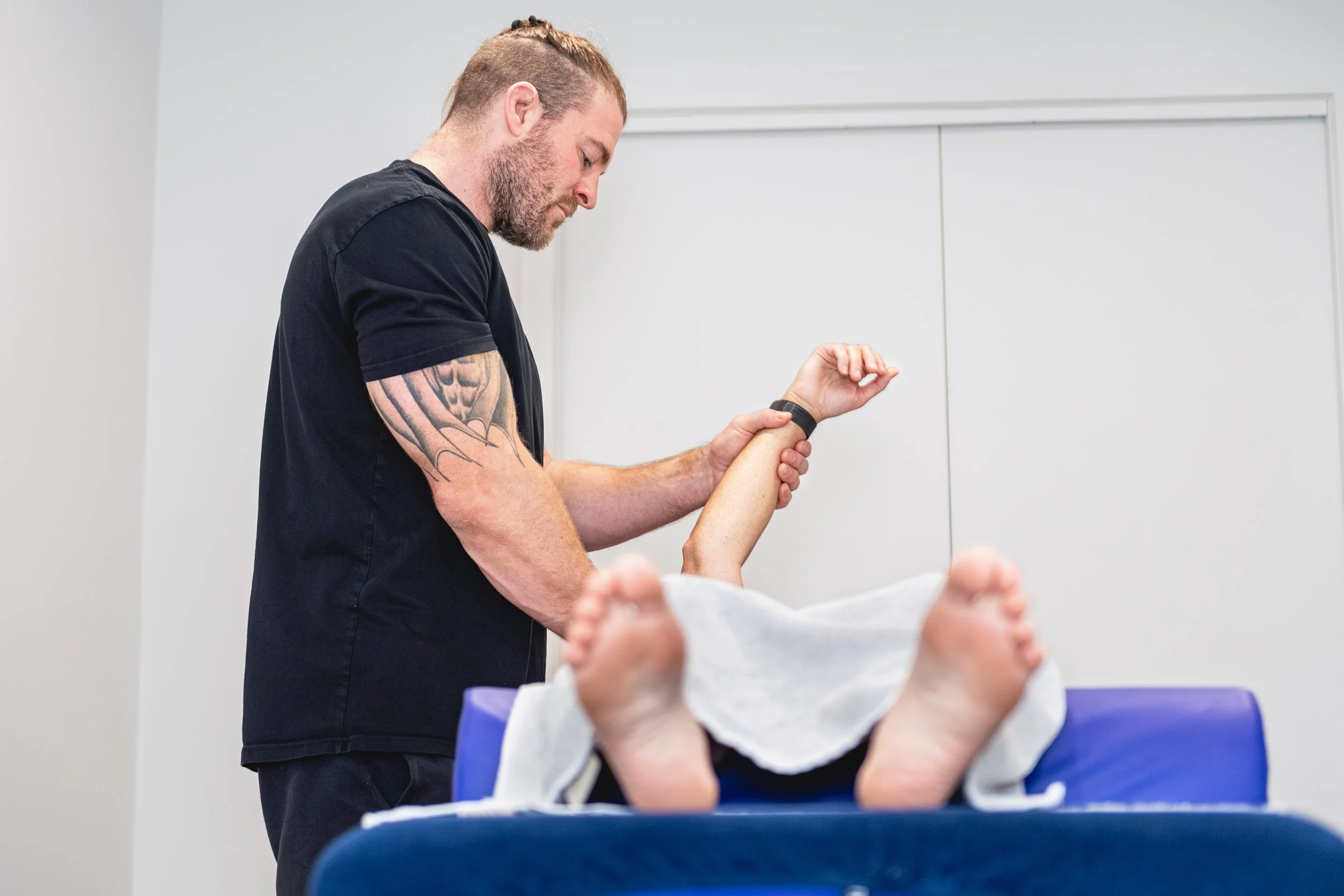 Nick Mann applying firm pressure to a client's lower back during remedial massage