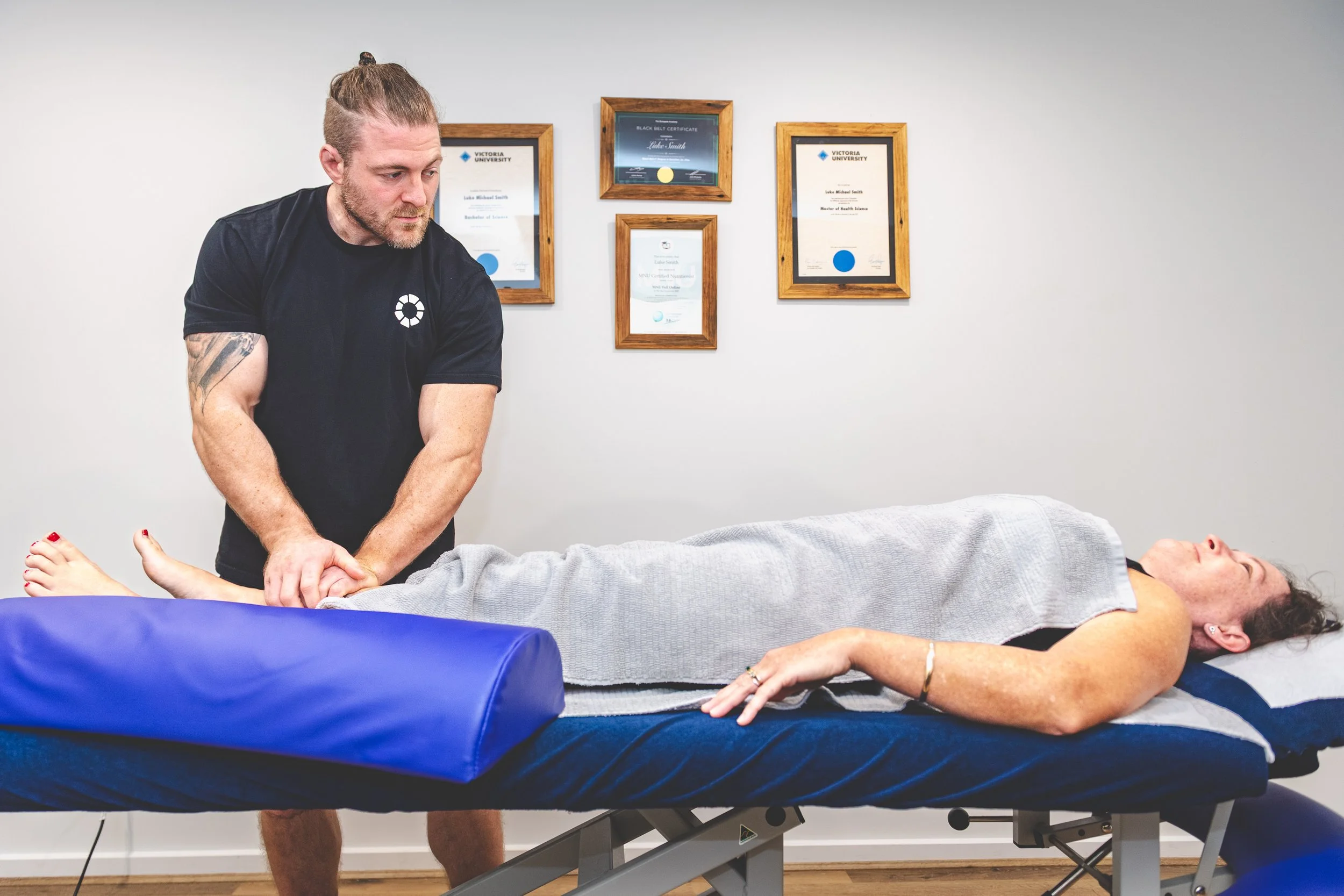 Nick Mann guiding a client through a hip stretch during a remedial massage session