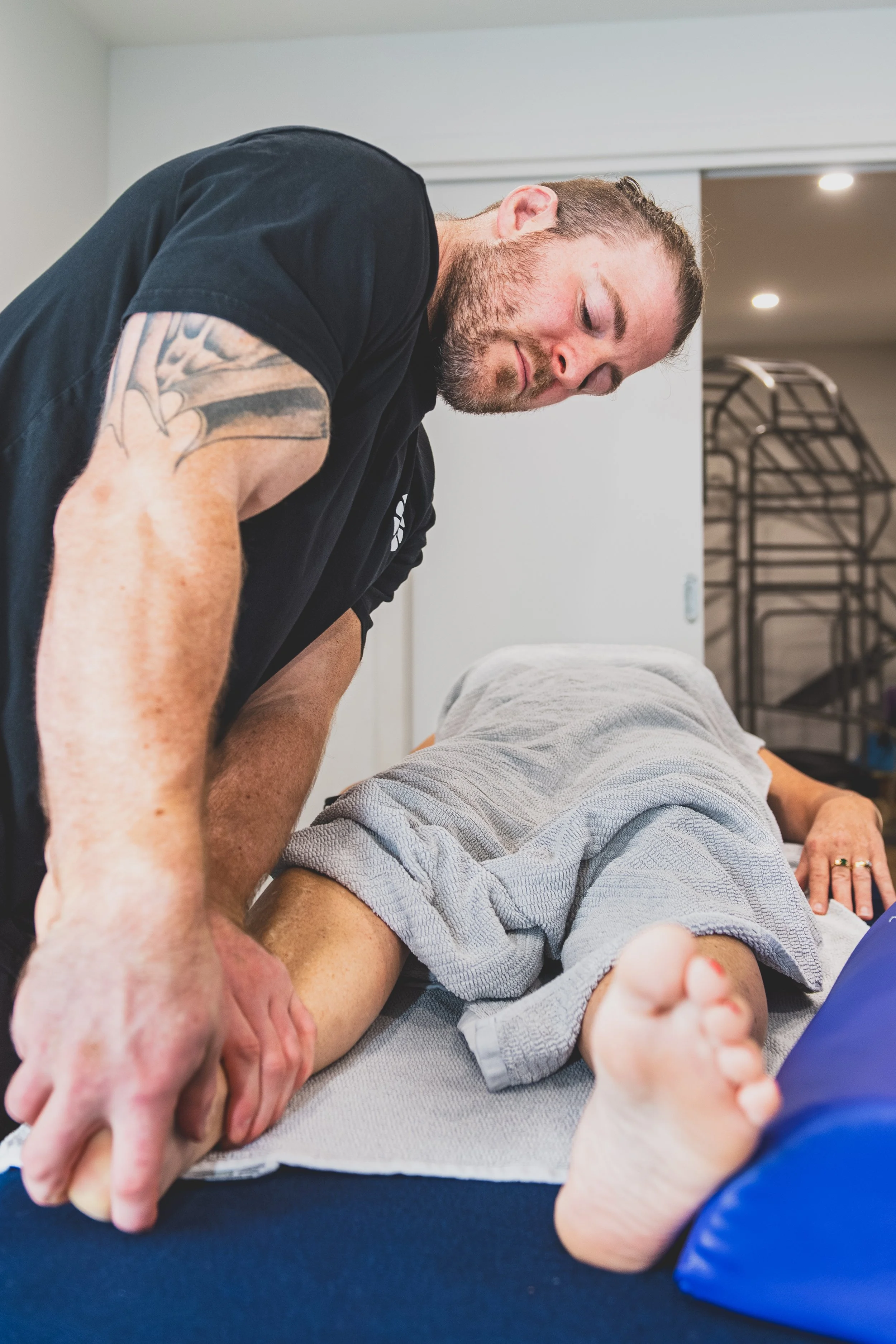 Nick Mann stretching a client's leg during a remedial massage session, Mixed Osteo Kensington