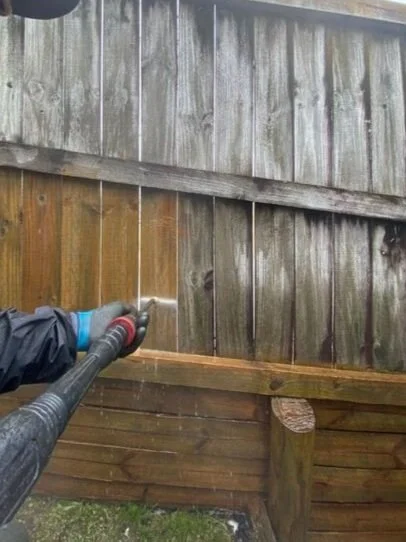 Fence being washed using moss & mould solution and water blasting by a maintenance technician from DCW Services
