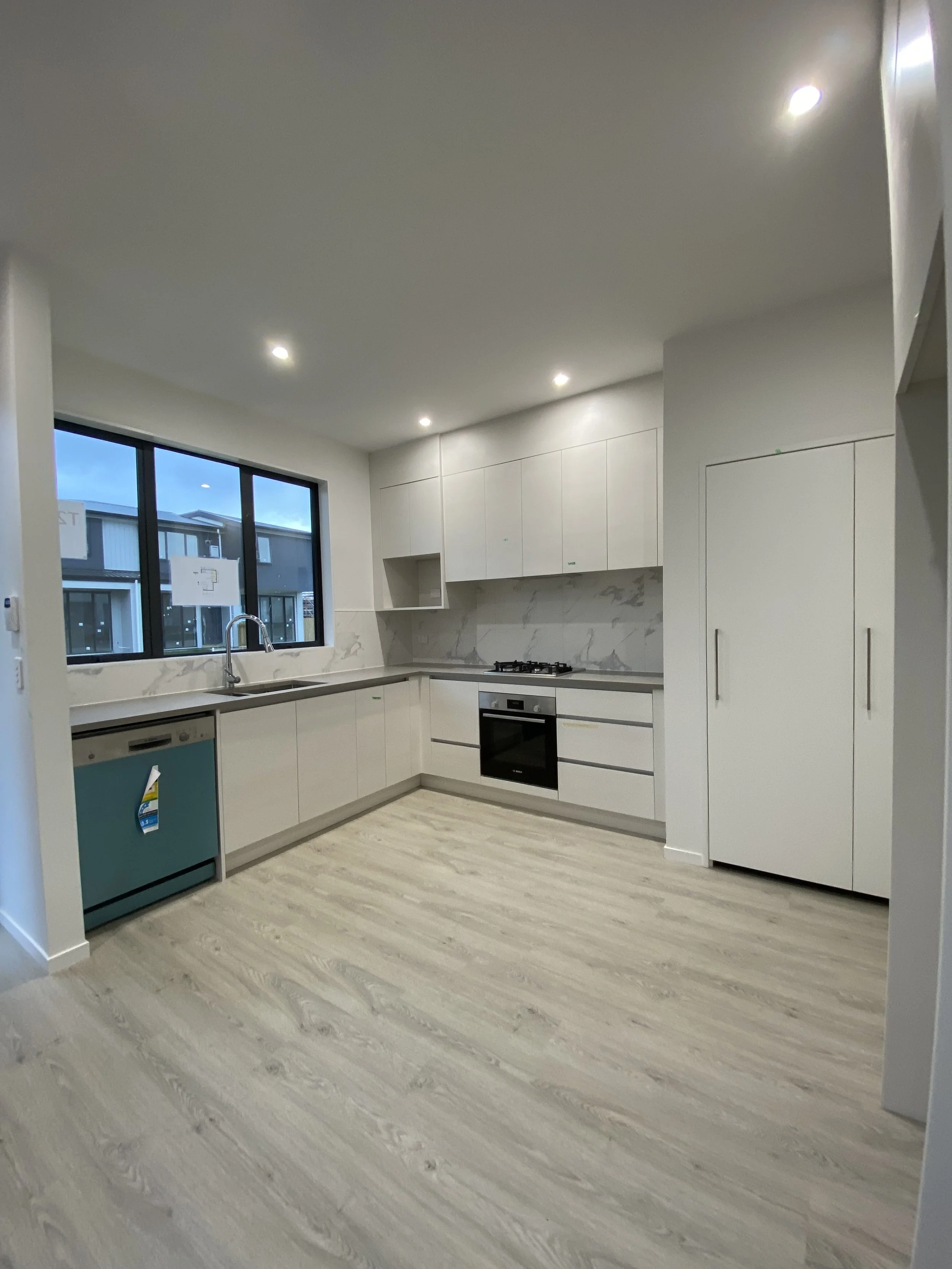 Kitchen fitout with cabinetry flooring and benchtop installation in South Auckland new build development