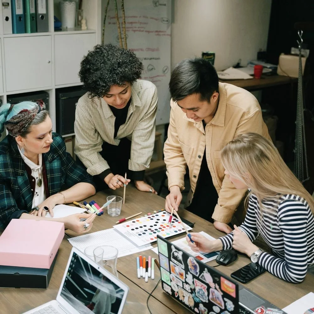 A group of marketers around a desk discussing a project during business training
