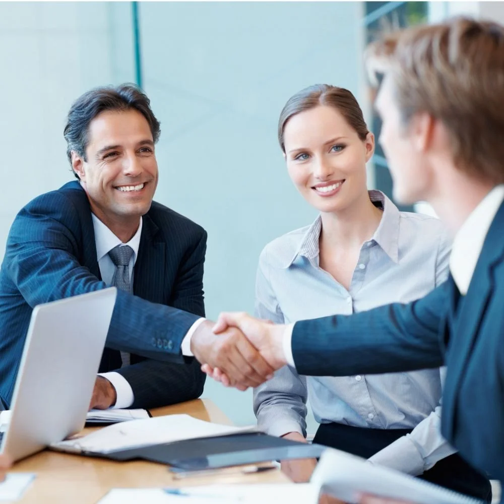 Two business colleagues shaking hands on a deal with a business consumer during a Sales executive apprenticeship