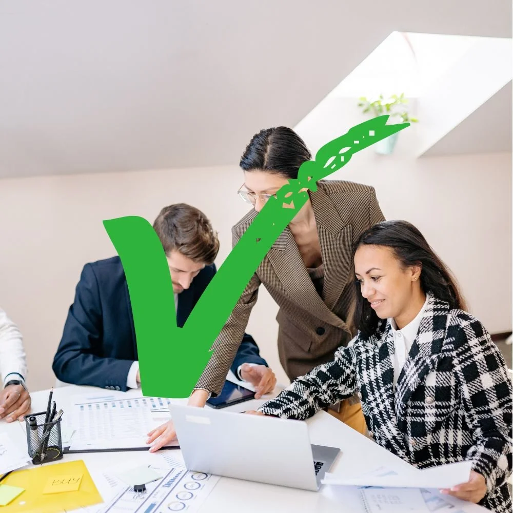A male and two female work colleagues discussing  business results on paper and a laptop with a green tick over the image for Apprenticeship Myths blog