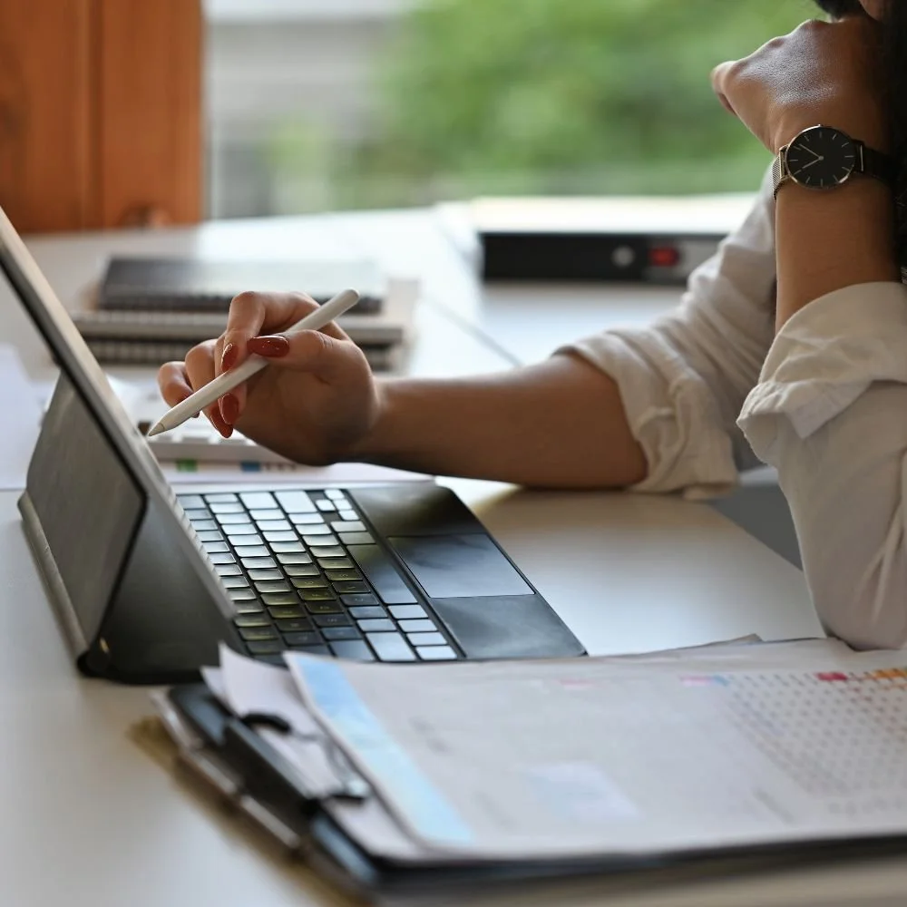 Close up of a female working at a laptop with papers on the desk during an Administration Assistant Apprenticeship
