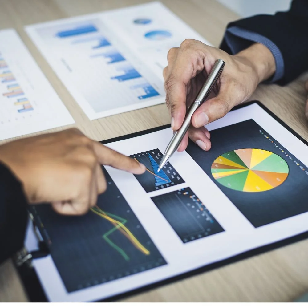 Close up of two hands pointing to data sheets on a desk during the Improvement Technician apprenticeship