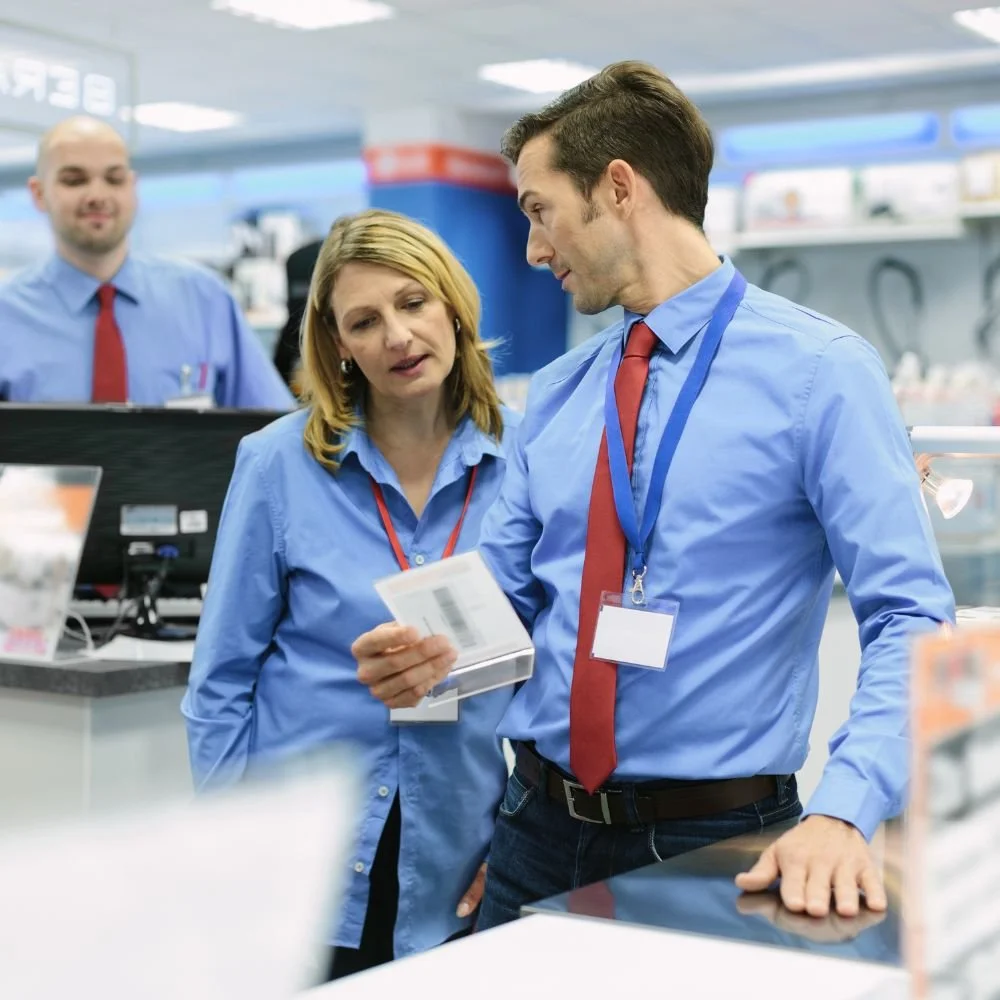 A male on a retail manager apprenticeship supporting a team member with training on the shop floor
