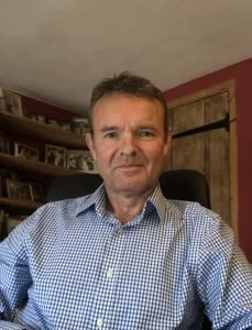 Neale McArdle Chair of Governors with short dark hair and a blue check shirt