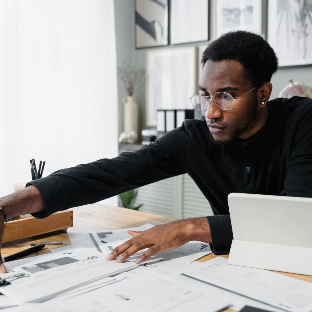 A Man shuffling paperwork on his desk during a Payroll Assistant Manager Apprenticeship