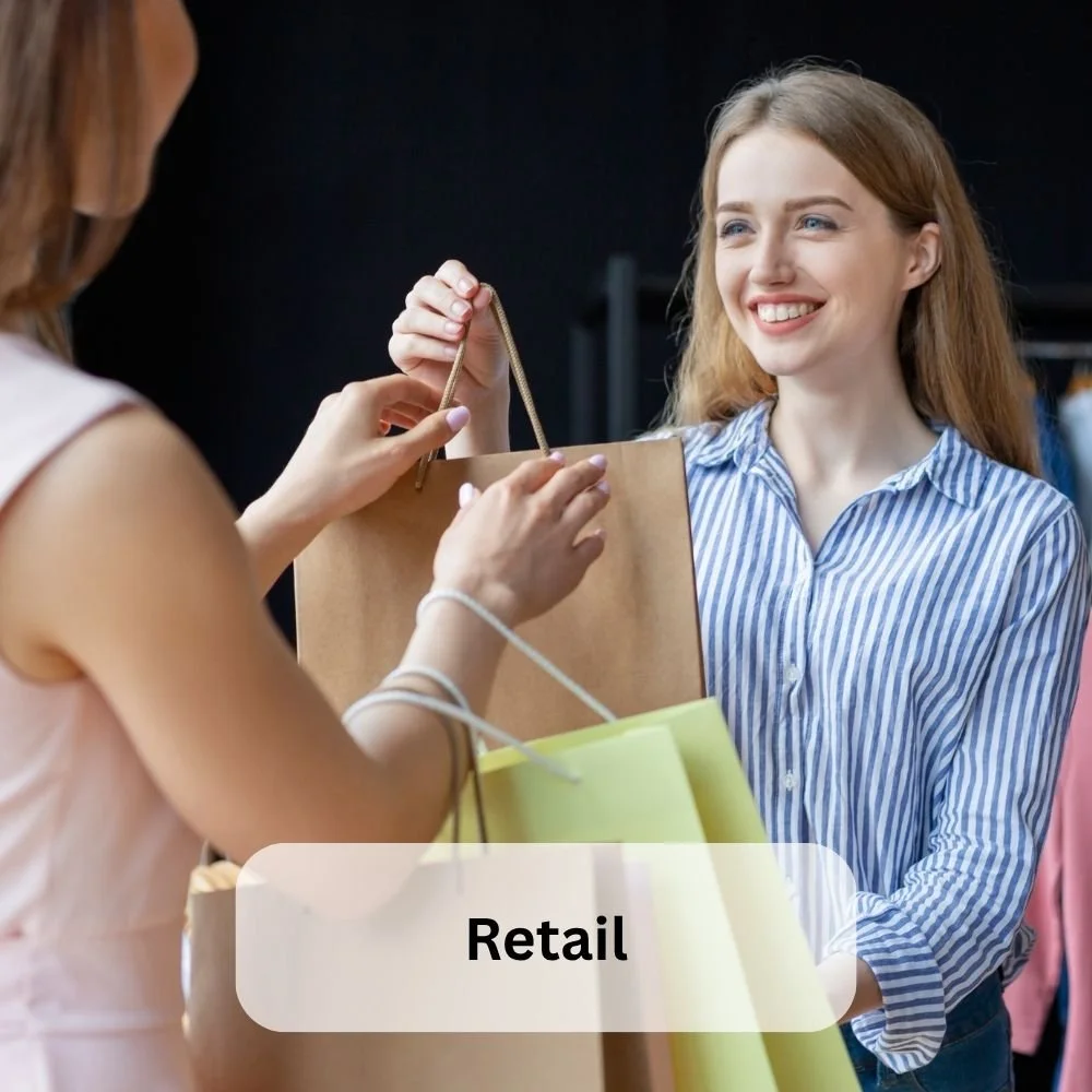 A shop assistant handing a bag to a customer-retail, sector specific apprenticeships