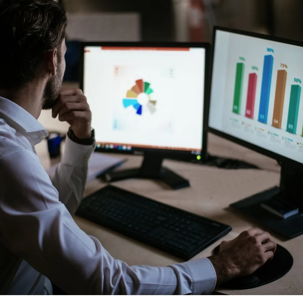 A man sat at a computer studying data during his Market Research Executive apprenticeship