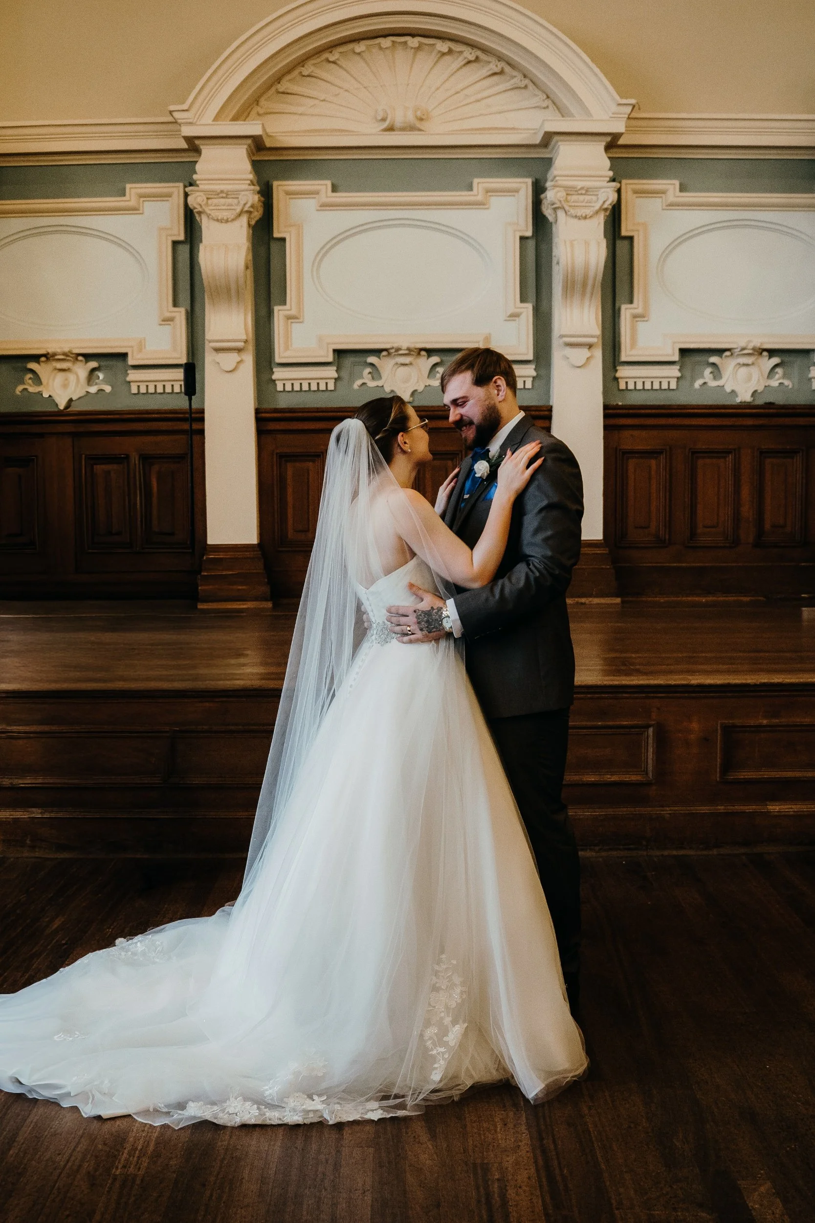 Bride and groom sharing a dance in a decorated indoor wedding venue.