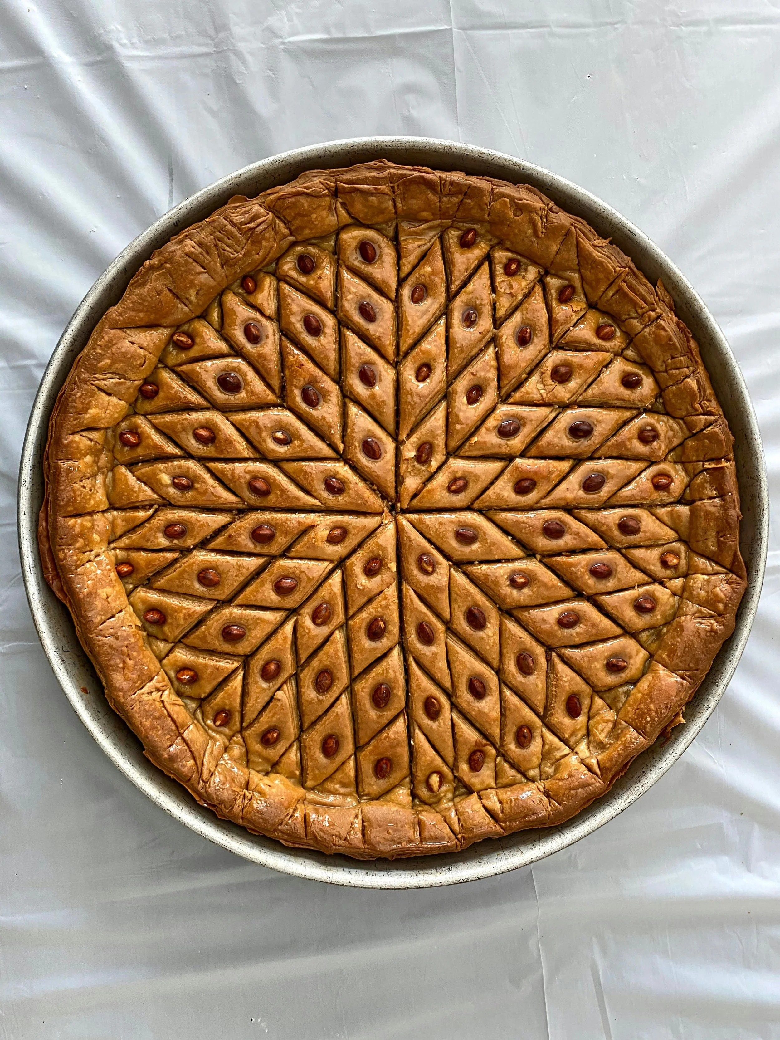 A decorated pie in a dish on a white tablecloth