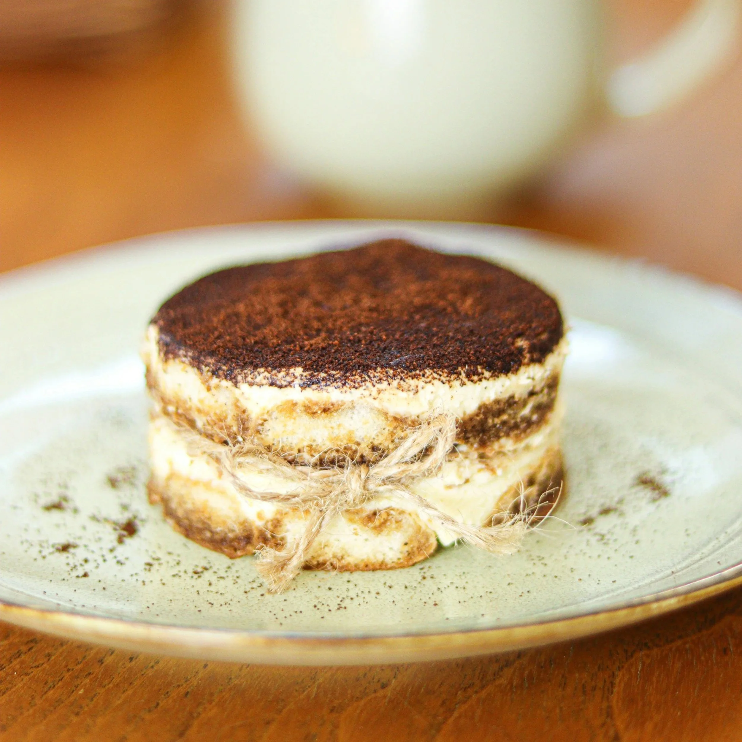 Tiramisu on a plate with spoon and coffee