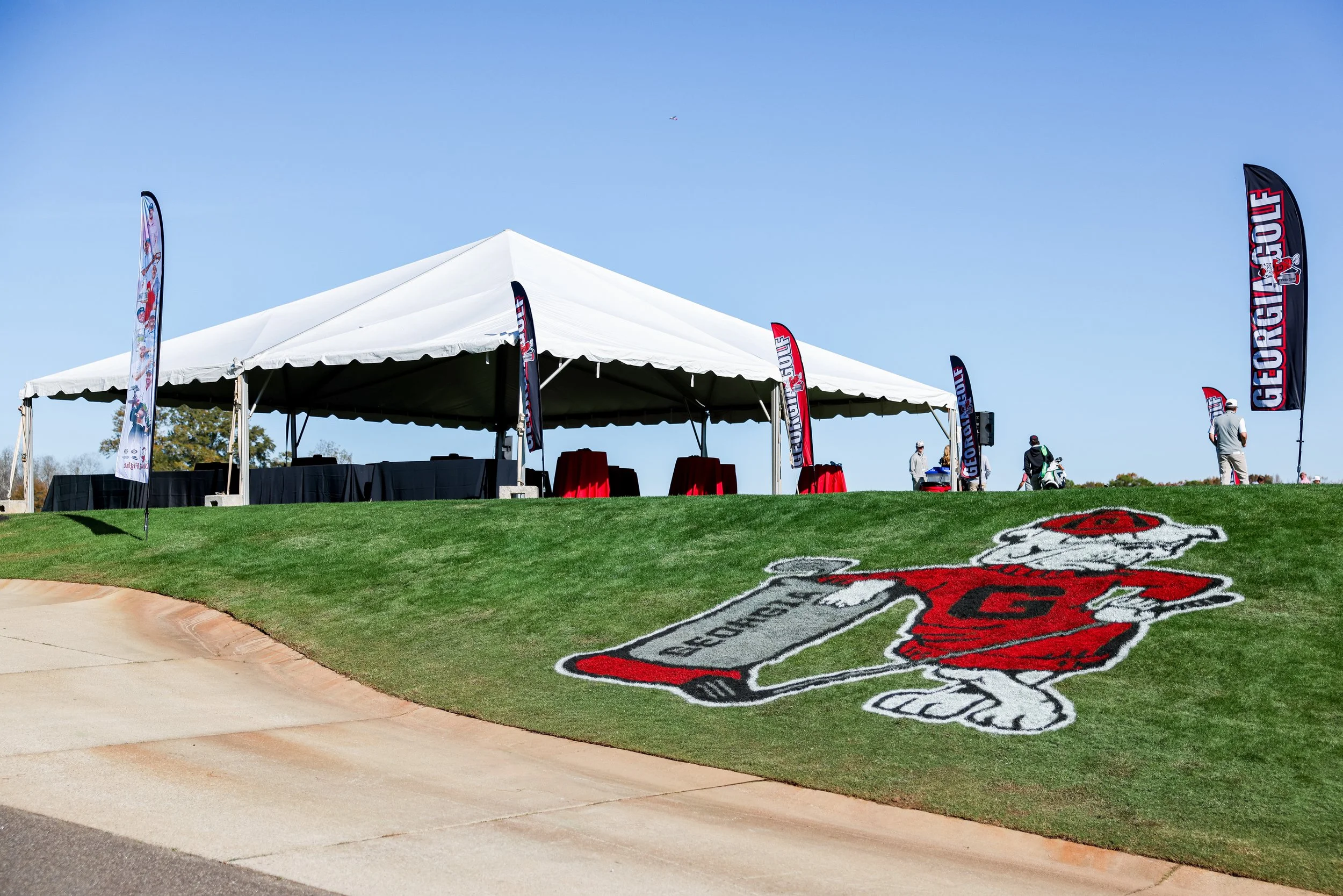 A large white event tent with flags bearing